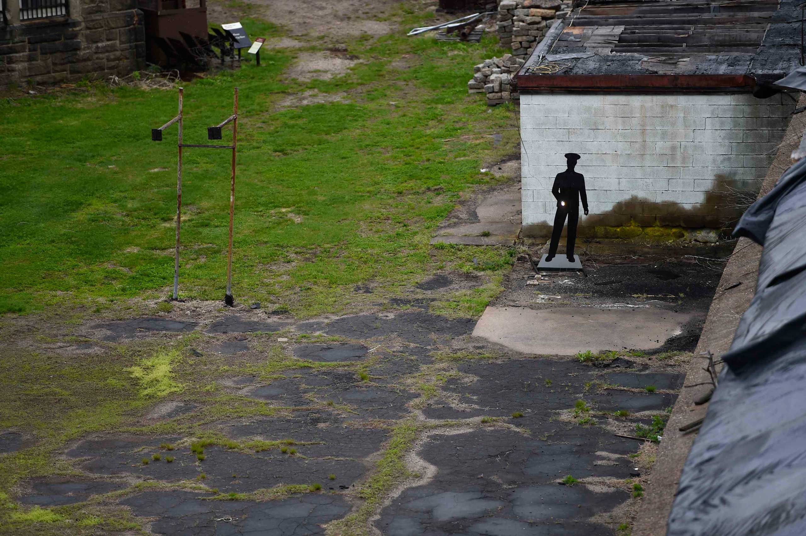 A cut-out prison guard silhouette with flashlight, part of a current exhibition at former prison Eastern State Penitentiary, stands in the grounds in Philadelphia, Pa., April 30, 2014.