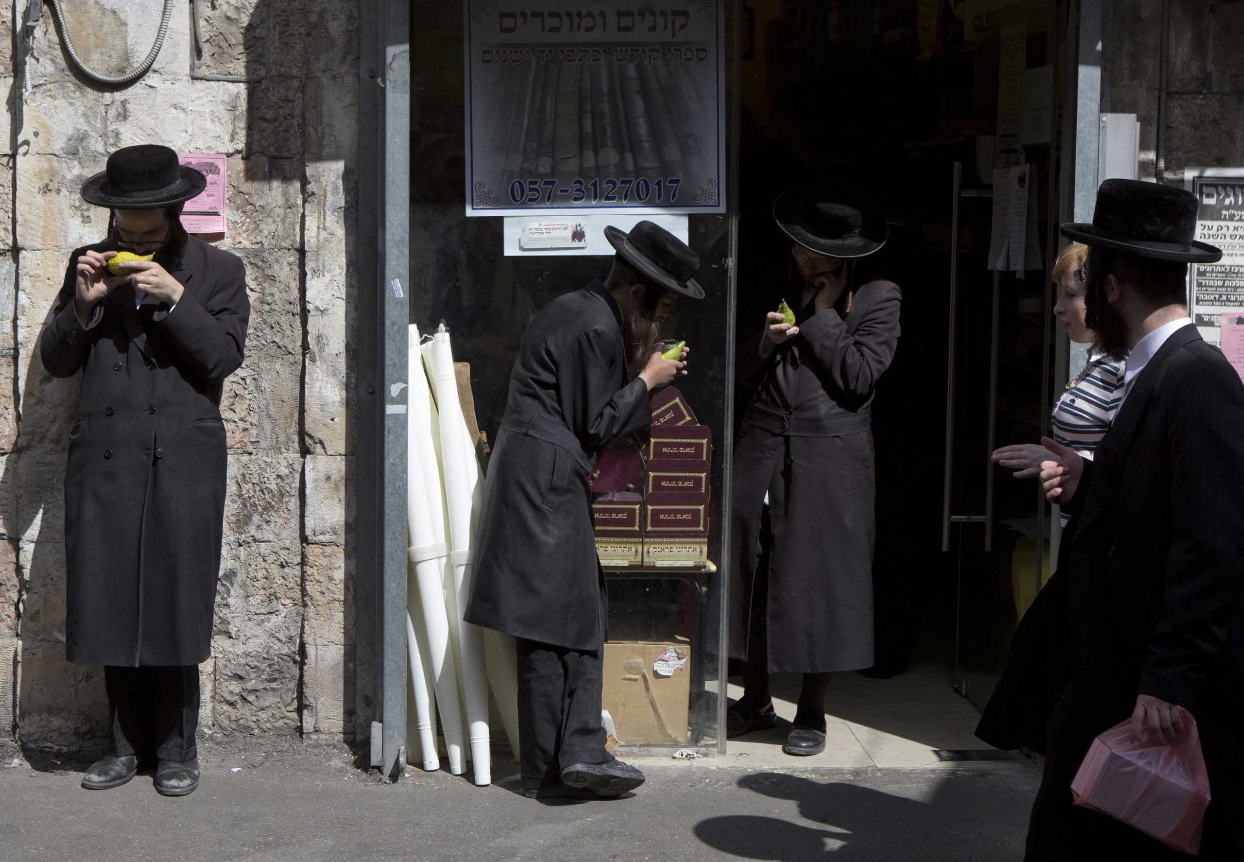 Ultra-Orthodox Jews inspect etrogs, or citrons, outside a shop in the Mea Shearim neighborhood in Jerusalem as they look to purchase an unblemished fruit ahead of the holiday of Sukkot, Oct. 7, 2014.