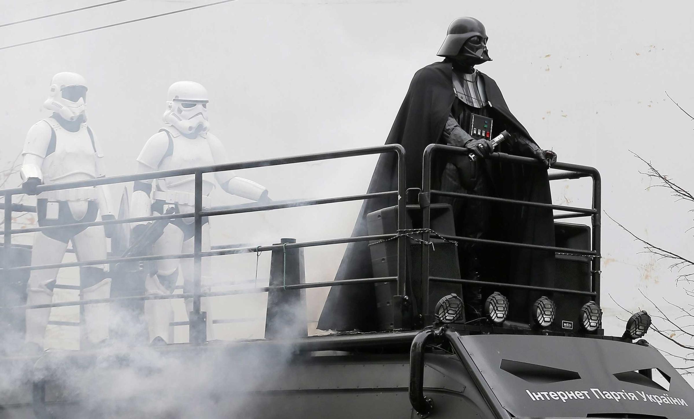 An impersonator of Star Wars character 'Darth Vader' stands on the roof of a van during an election campaign event for the Ukrainian Internet Party. Party members have legally changed their names to resemble 'Star Wars' characters. Kiev, Oct. 21, 2014.