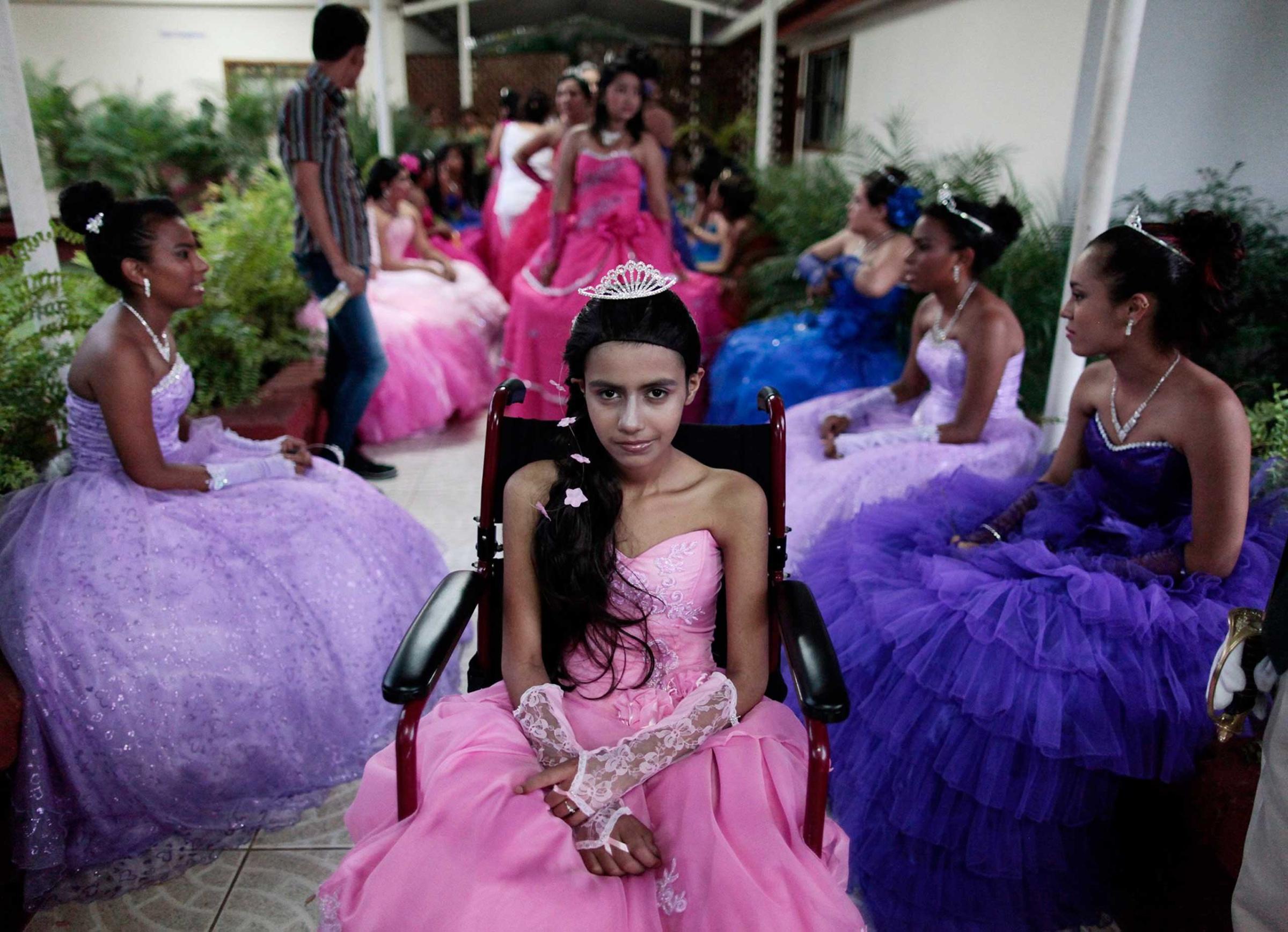 A cancer patient poses for a photo during her "Quinceanera" (15th birthday) party among other celebrants at a hotel in Managua