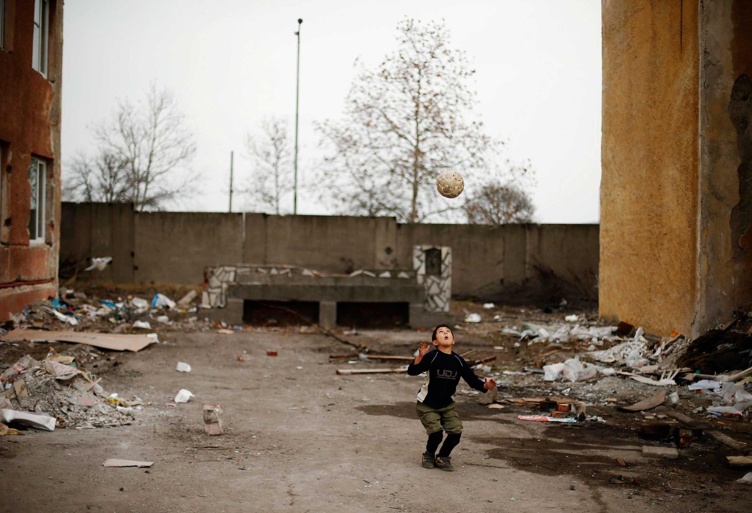 A Syrian refugee boy plays with a ball at a refugee centre in Harmanli