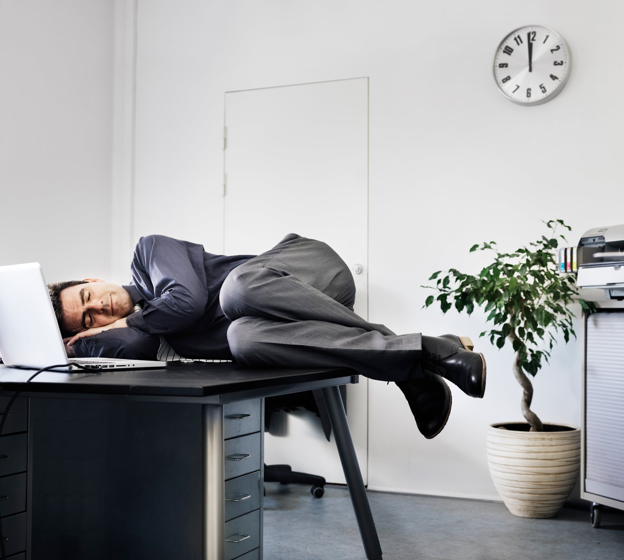 Businessman asleep on his office desk