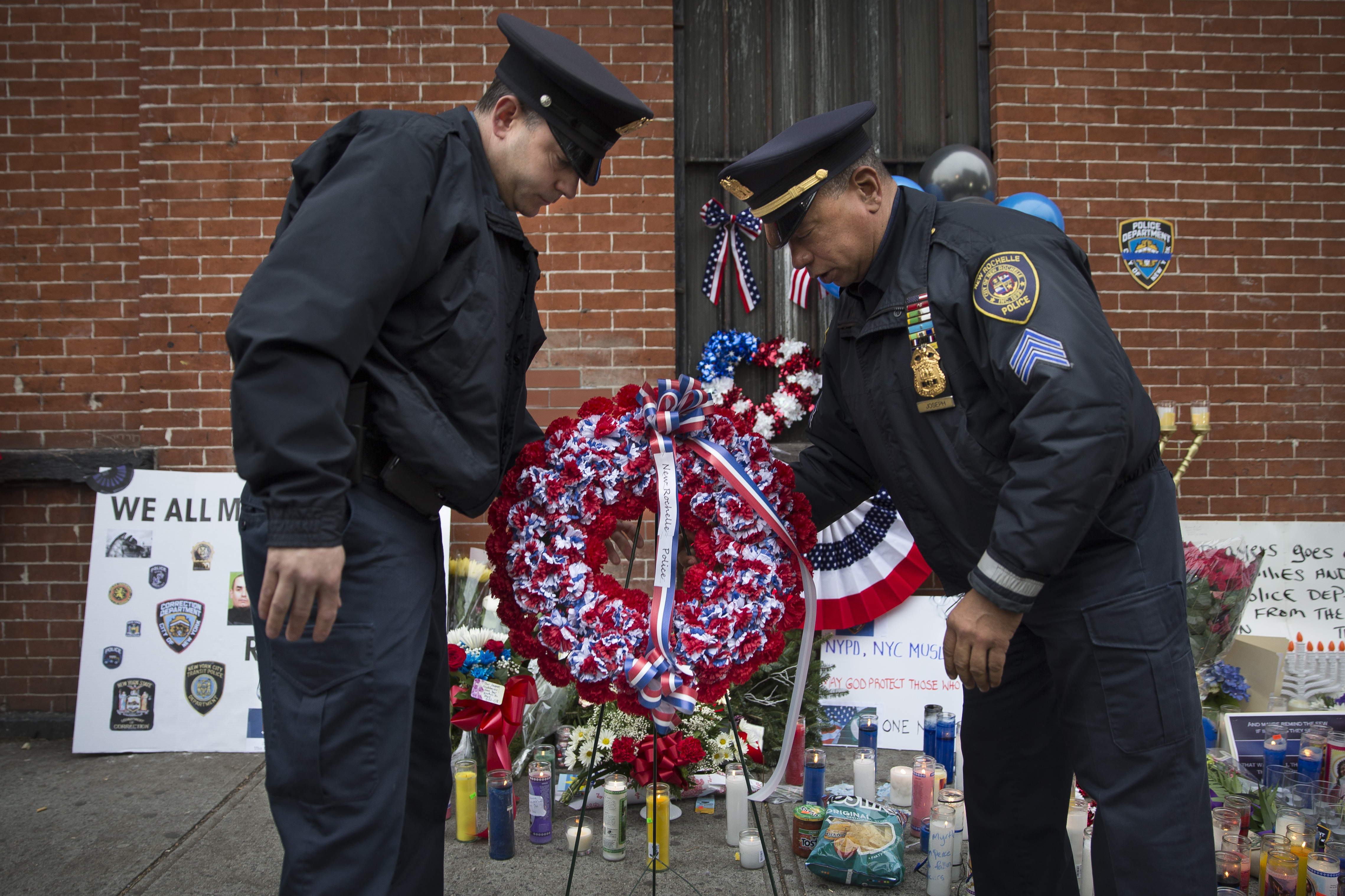 In this file photo, members of the New Rochelle, N.Y. police department place a wreath at a makeshift memorial near the site where NYPD officers Rafael Ramos and Wenjian Liu were murdered in the Brooklyn borough of New York, Dec. 22, 2014. (John Minchillo—AP)