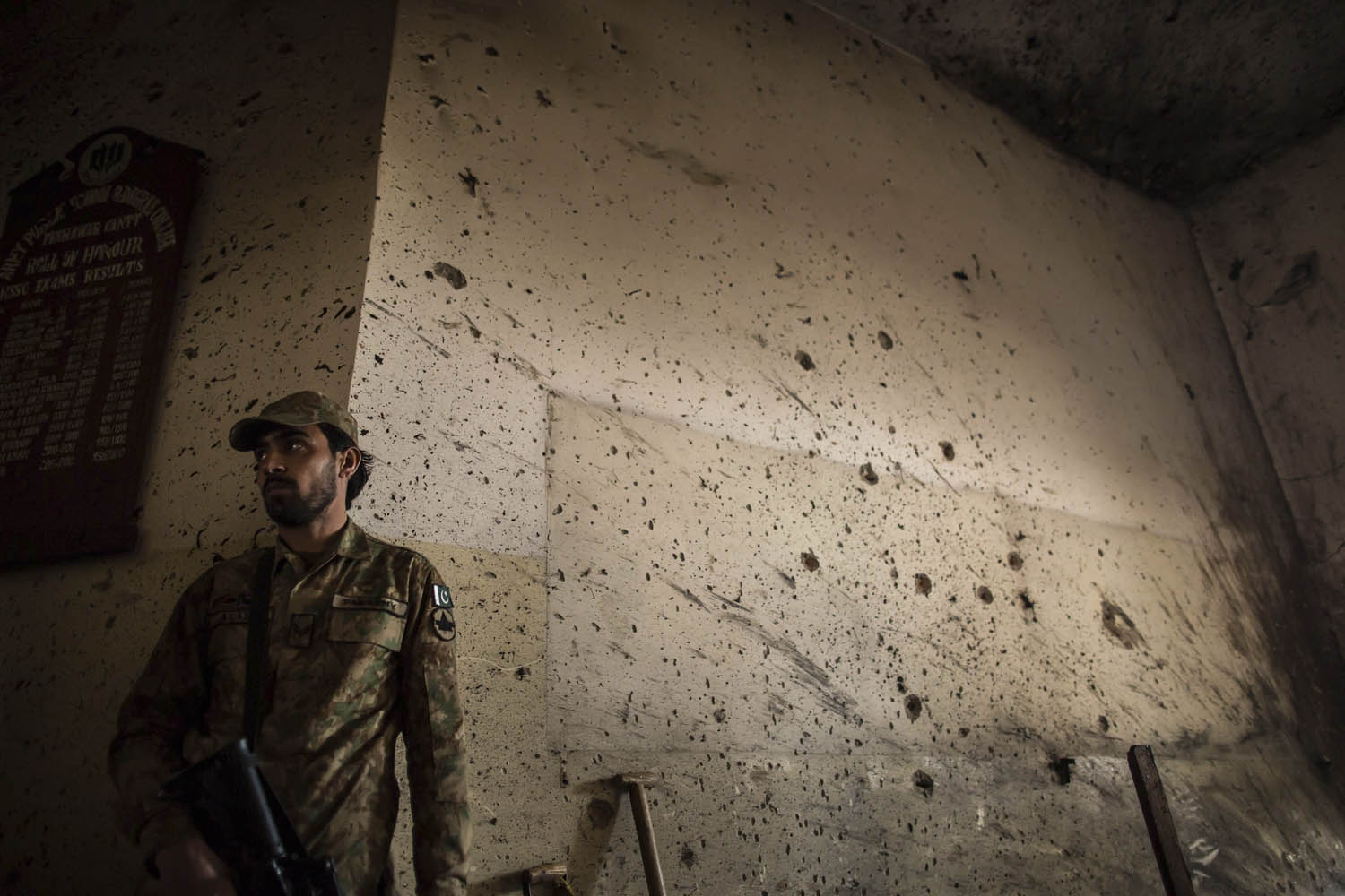 An army soldier stands guard inside the Army Public School, which was attacked by Taliban gunmen, in Peshawar