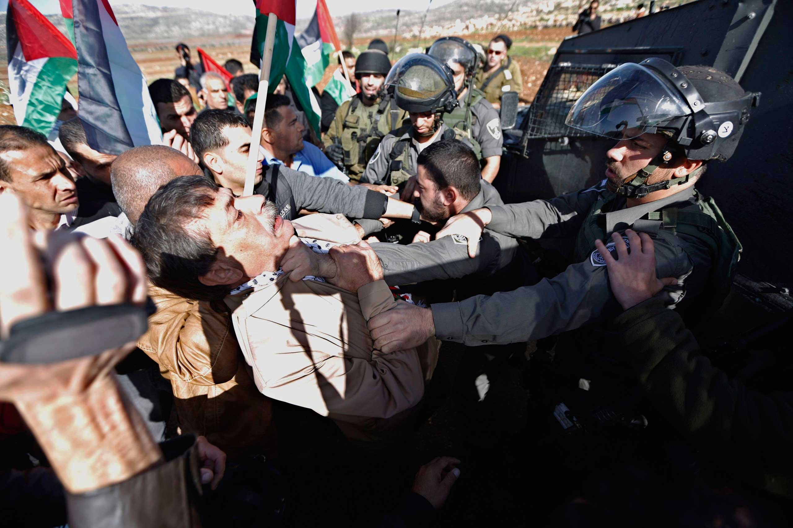 Dec. 10, 2014. Palestinian minister Ziad Abu Ein, left, scuffles with an Israeli border policeman in the village of  Turmus Aya near the West Bank city of Ramallah. Abu Ein died shortly after being hit by Israeli soldiers during a protest in West Bank.