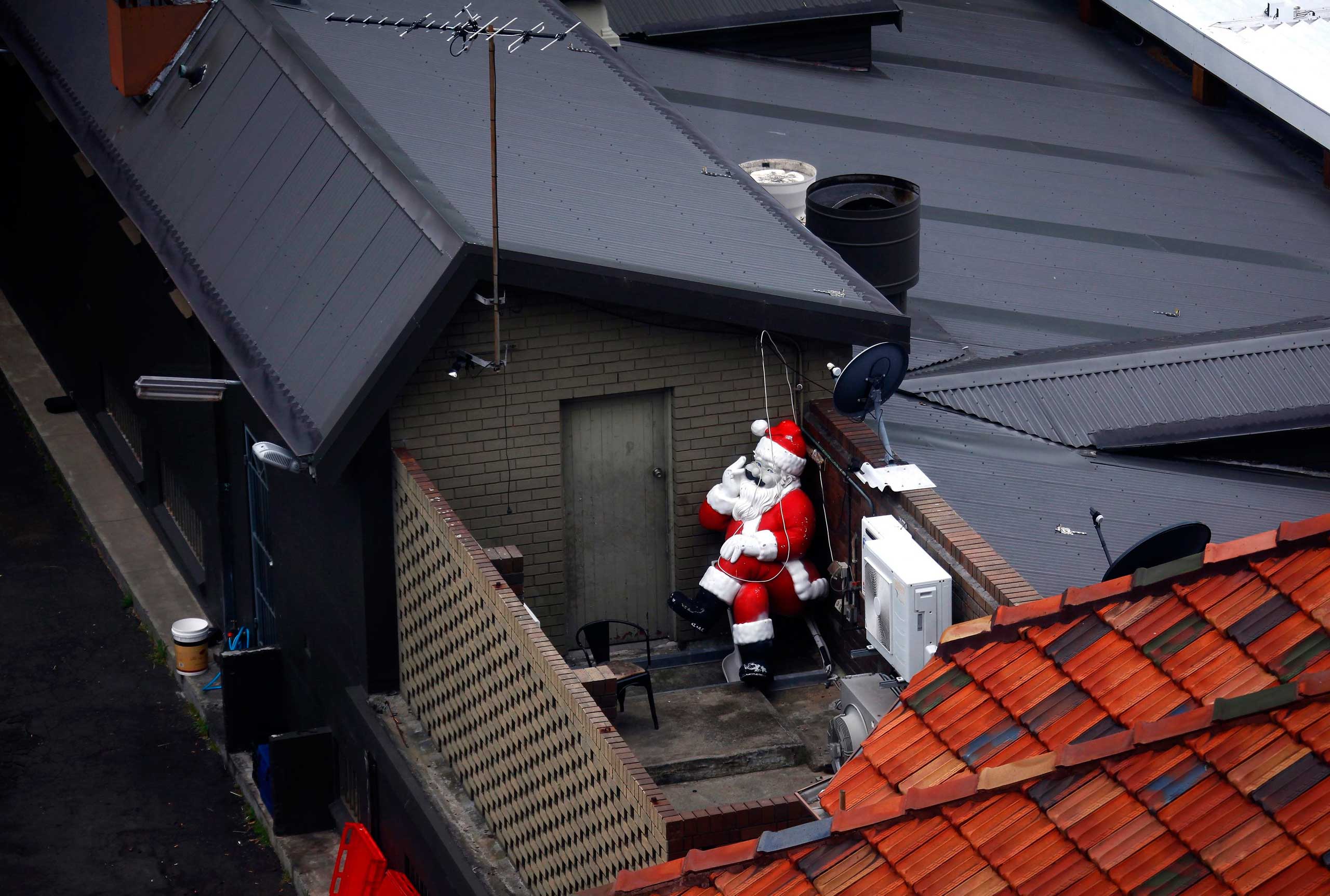 Nov. 10, 2014. A statue of Santa Claus, part of Christmas decorations for a pub in Sydney, can be seen placed at the back of the building before being put on display.