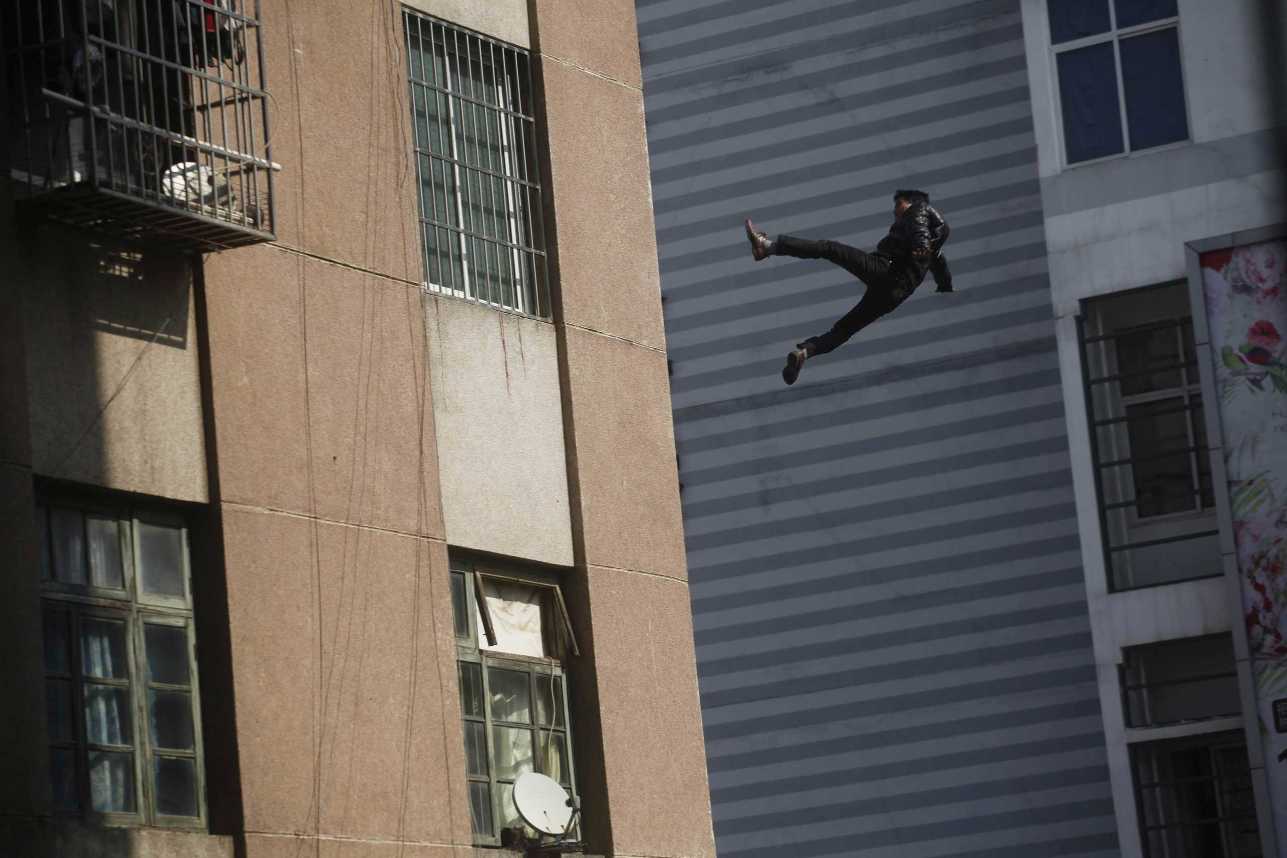 Dec. 8, 2014. A man falls from the top of a residential building in Liuzhou, Guangxi Zhuang Autonomous Region. Witnesses said that the man, who did not survive, slipped off from the edge of the building as he was shouting and stepping back from people trying to persuade him to leave the roof top.
