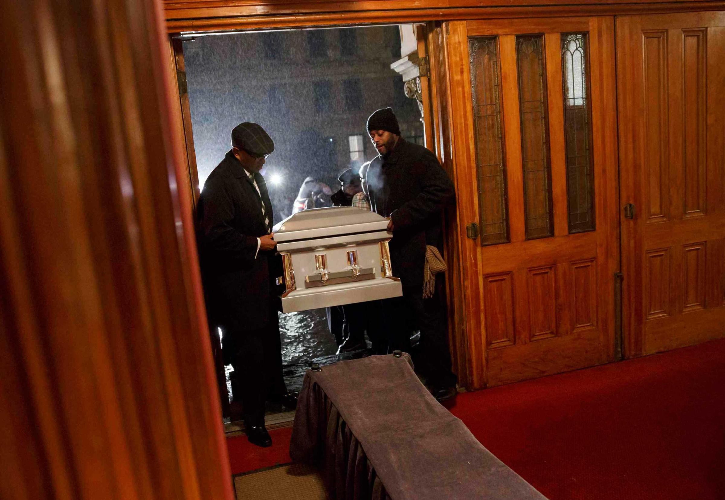 Men carry the coffin of Akai Gurley into the Brown Memorial Baptist Church before his wake in Brooklyn, New York