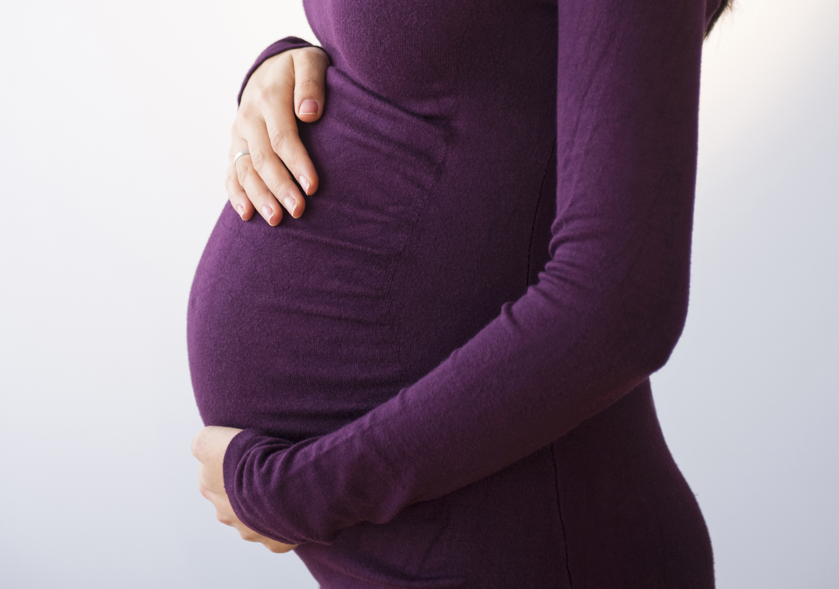 Pregnant Caucasian woman holding stomach