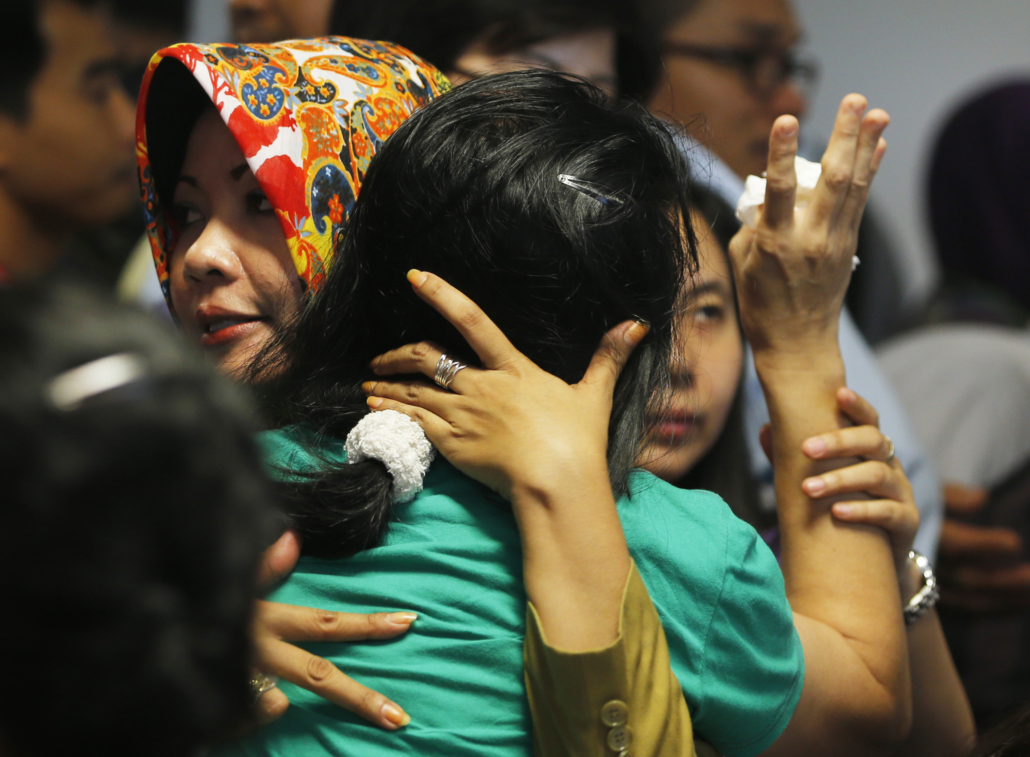 A government official, left, tries to calm a family member of passengers on board AirAsia Flight QZ 8501 at a waiting area in Juanda International Airport in Surabaya, Indonesia, on Dec. 30, 2014 (Beawiharta—Reuters)