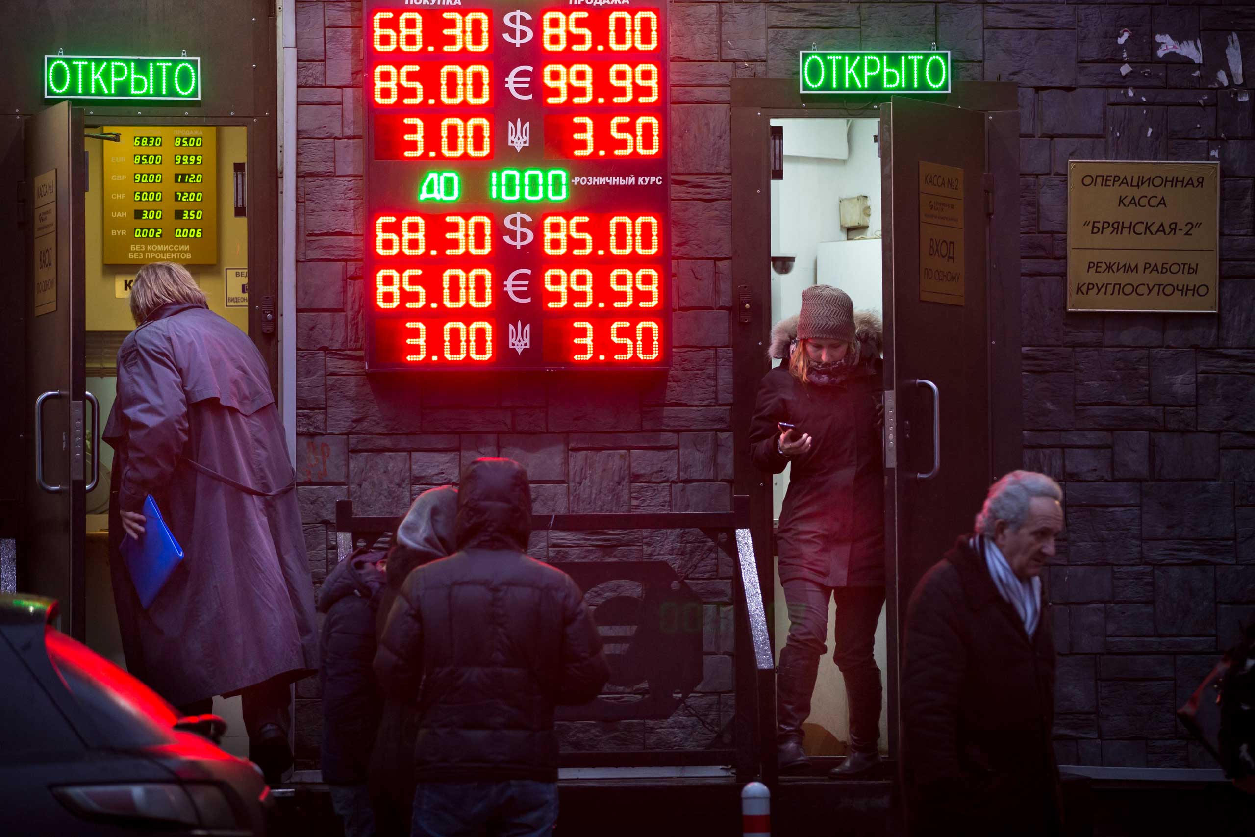 People wait to exchange their currency as  signs advertise the exchange rates at a currency  exchange office in Moscow, Dec. 16, 2014. (Alexander Zemlianichenko—AP)