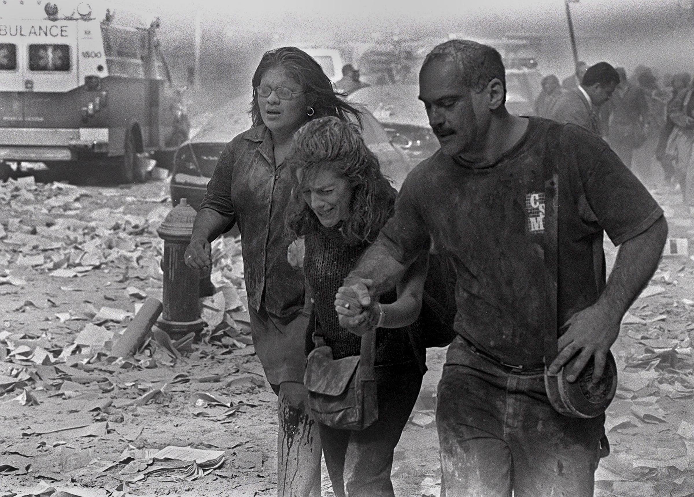 Julie McDermott, center, walks with other victims as they make their way amid debris near the World Trade Center in New York City on Sept. 11, 2001.