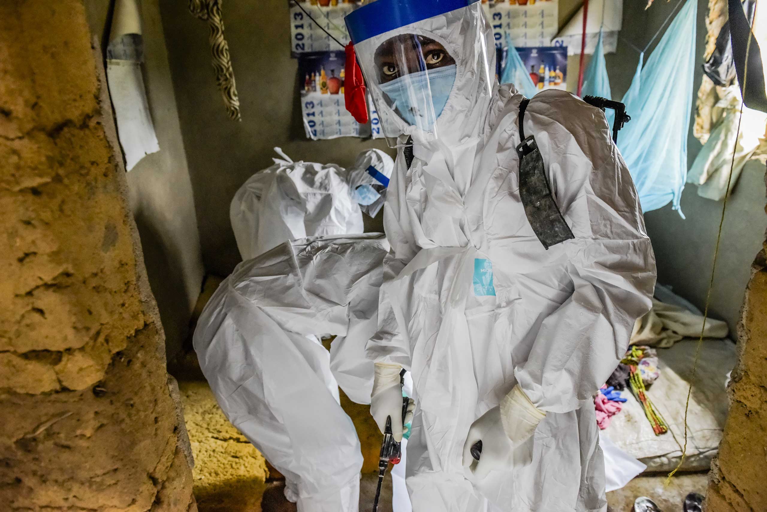 A burial team extracts the body of Isatu Sesay, 16, an Ebola victim, from her home in Kissi Town, Sierra Leone, Nov. 22, 2014. (Daniel Berehulak—The New York Times/Redux)
