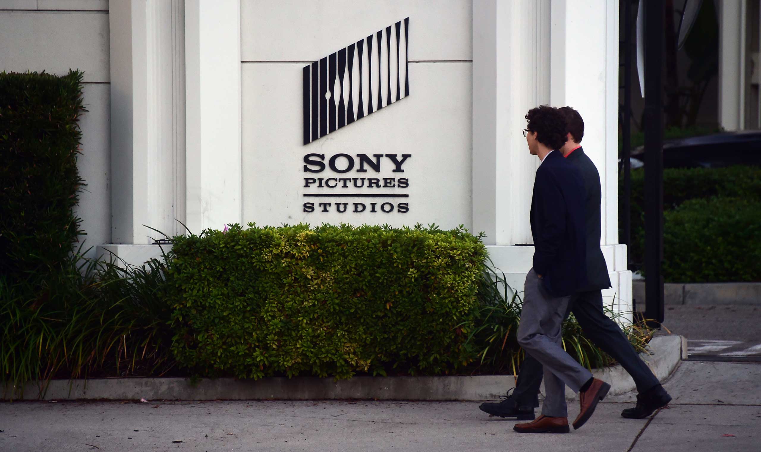 Pedestrians walk past an exterior wall to Sony Pictures Studios in Los Angeles on Dec. 4, 2014. (Frederic J. Brown—AFP/Getty Images)