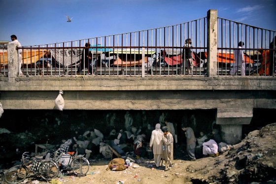 A view of Pul-e Sukhta bridge from the banks of the dried Kabul river on Aug. 26, 2014. While hundreds, often thousands, of addicts swarm below in a self-fueling network of drugs, crime and despair, life seems to continue unaffected above.
