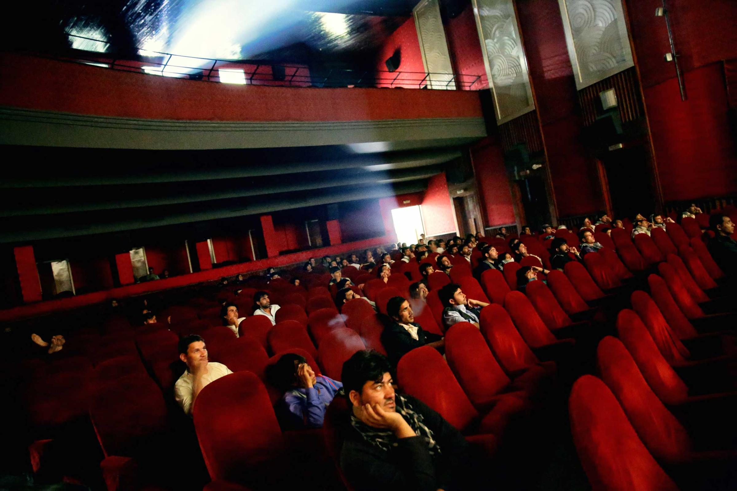 Young men smoke hashish and watch a Bollywood film at the recently refurbished Cinema Ariana in central Kabul on Aug. 18, 2014.