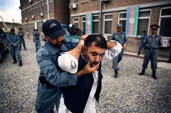 Afghan National Police officers from the Anti-Narcotics Quick Reaction Force (ANQRF) carry out a brutal stop and search scenario exercise intended for drug traffickers at a training centre in Kabul on Aug. 25, 2014.