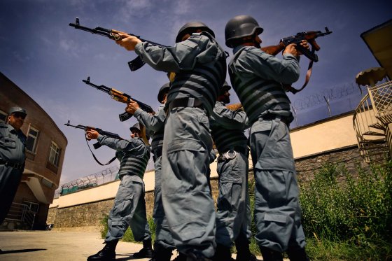 Afghan National Police officers from the Anti-Narcotics Quick Reaction Force (ANQRF) aim back-to-back holding Kalashnikov rifles as they performs exercises at a training centre in Kabul on Aug. 26, 2014.