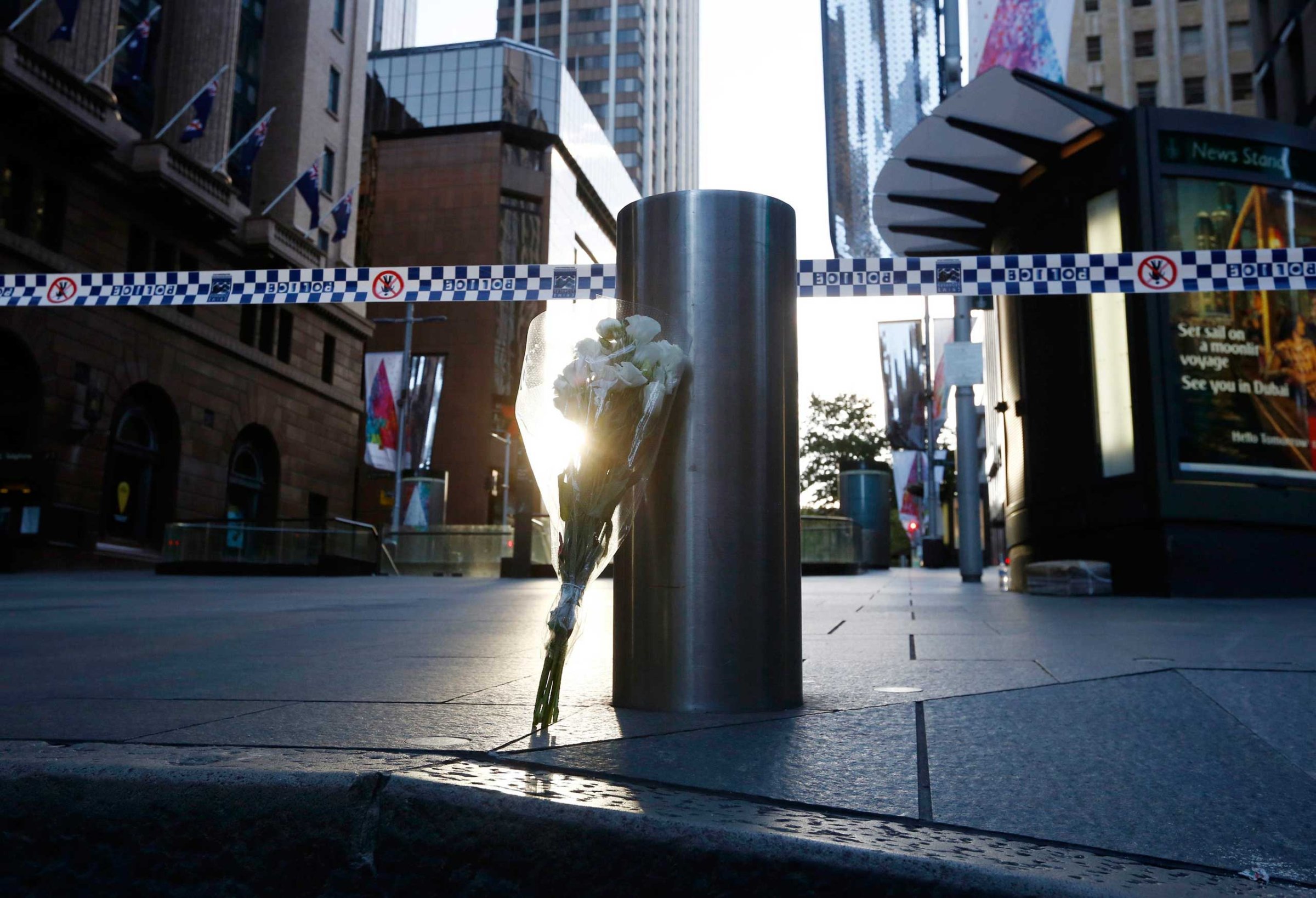 A bouquet is pictured under police tape near the cordoned-off scene of a hostage taking at Martin Place after it ended, early on Dec. 16, 2014.