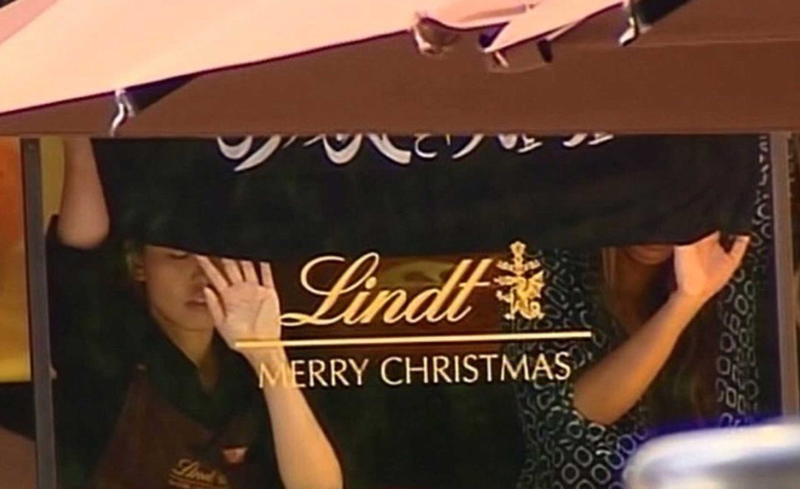 This screengrab taken from the Australian Channel Seven broadcast shows hostages holding up a flag with Arabic writing inside a cafe in the central business district of Sydney on Dec.15, 2014.