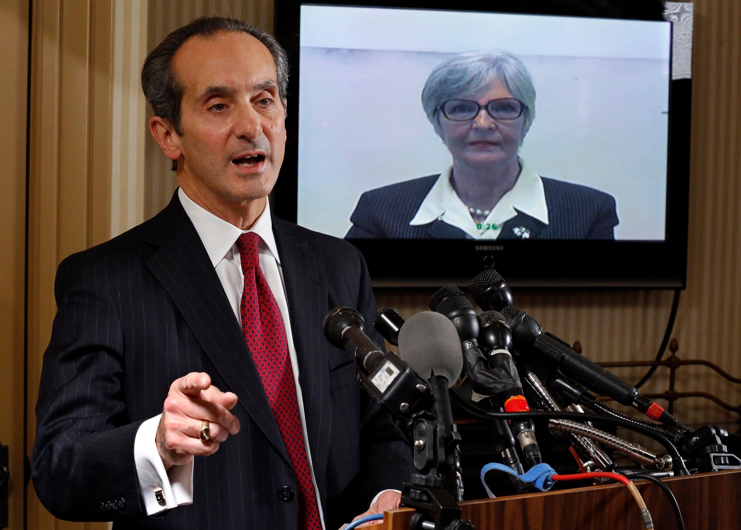 Tamara Green, the plaintiff in a defamation lawsuit claiming that she was "sexually assaulted by comedian Bill Cosby in the 1970s" watches by video link from California as her attorney Joseph Cammarata (L) speaks about the suit that they have filed to a news conference in Washington on Dec. 10, 2014.