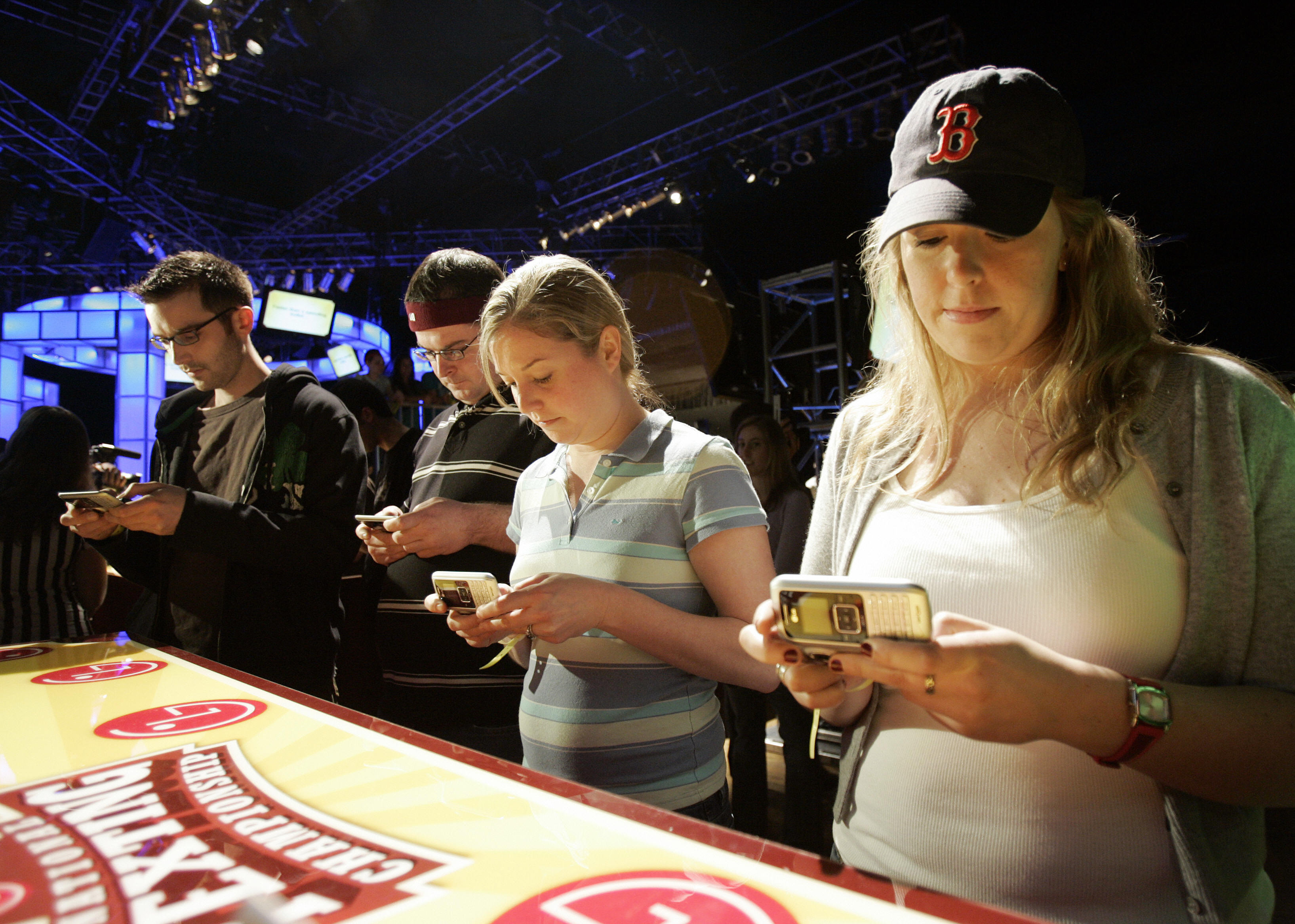 Vanessa LeBlanc (R), Susan Mygatt (2nd R) and others compete in an early round of the LG National Texting Championship, 21 April 2007, at the Roseland Ballroom in New York, sponsored by LG Mobile Phones. (STAN HONDA&mdash;AFP/Getty Images)