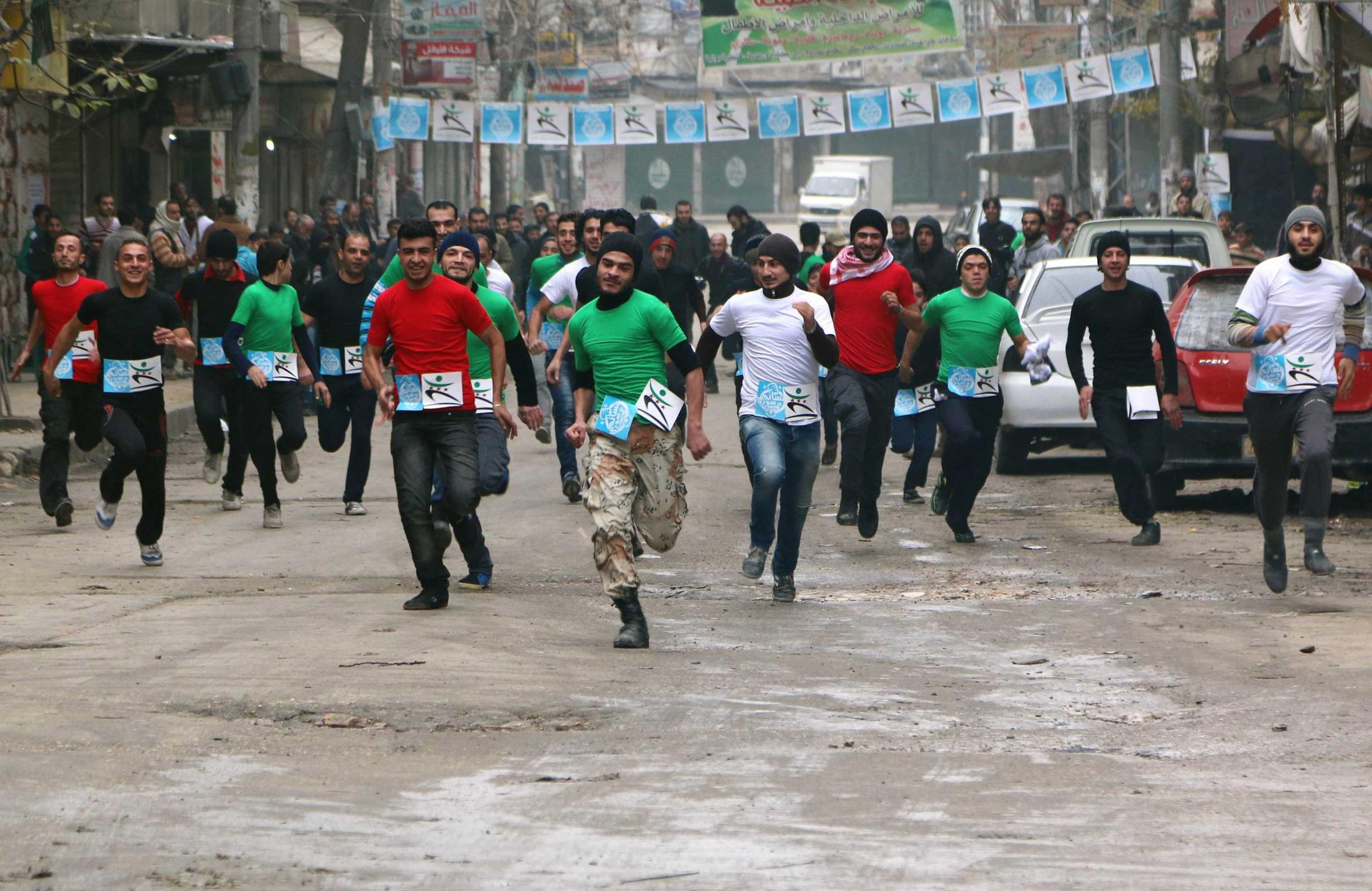 Participants compete in a running race along a street in Aleppo's Bustan al-Qasr neighbourhood