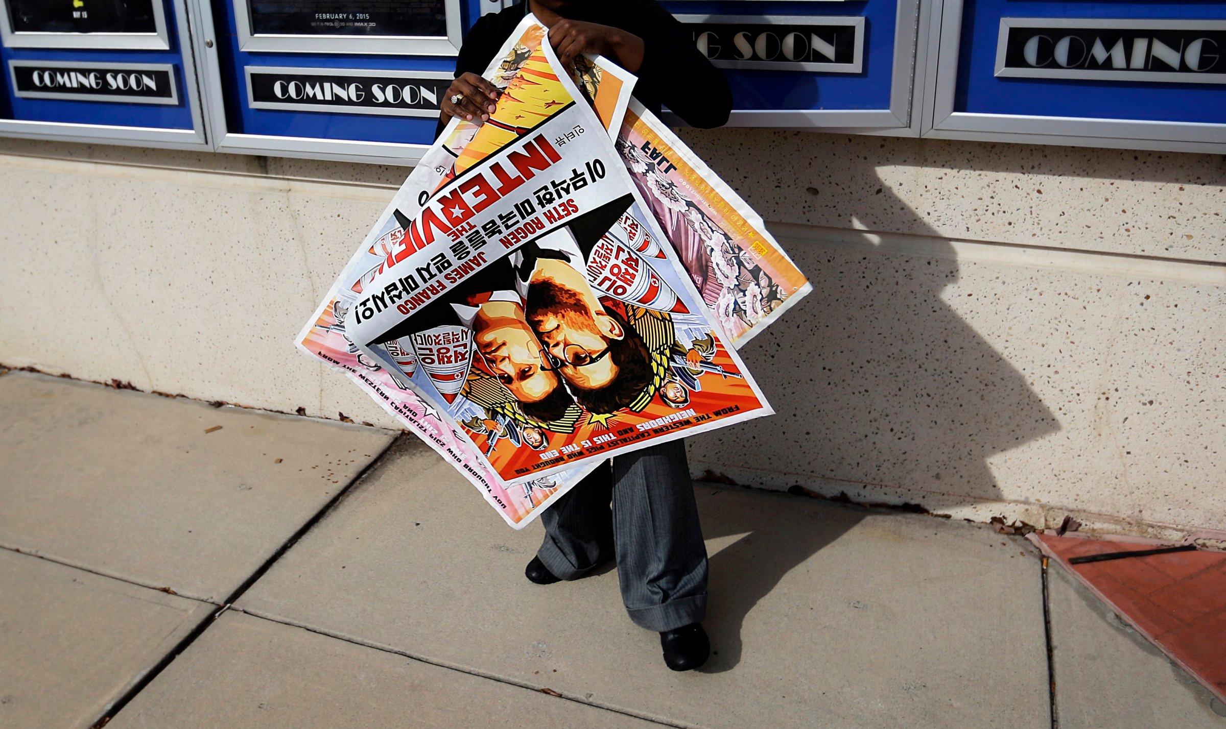 A poster for the movie "The Interview" is carried away by a worker after being pulled from a display case at a Carmike Cinemas movie theater on Dec. 17, 2014, in Atlanta.