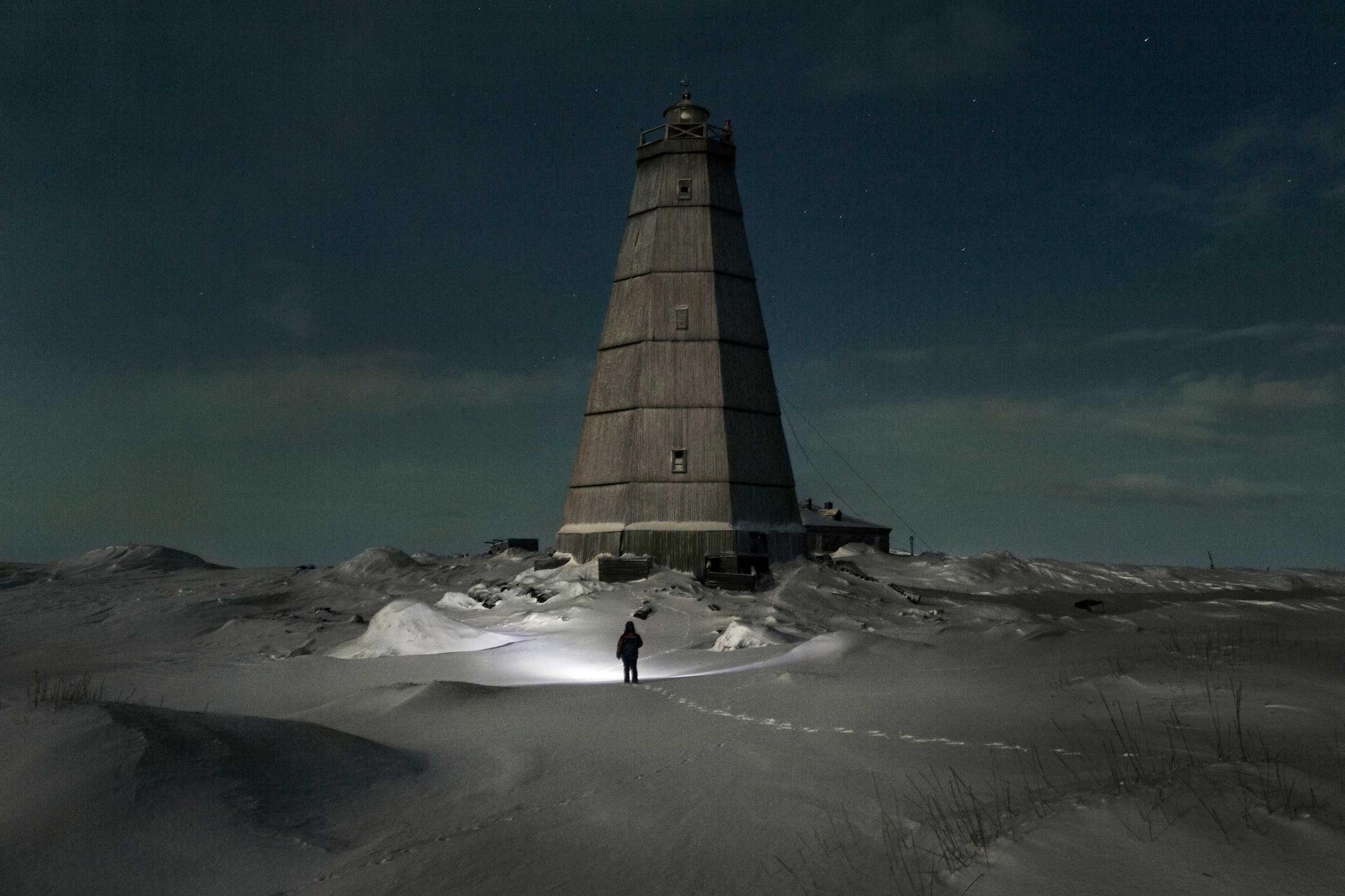 Slava walks to the old lighthouse near Hodovarikha meteorological station to take (dismantle) some fire wood from it’s walls. Full moon.