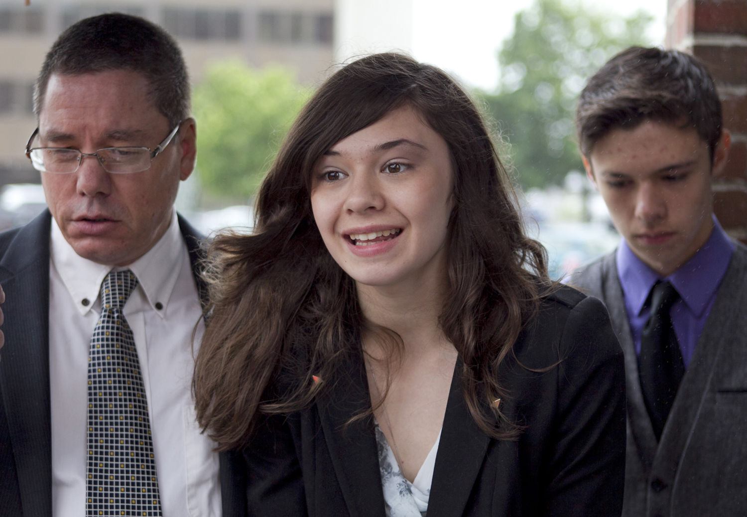 In this file photo, transgender student Nicole Maines, center, speaks to reporters as her father Wayne Maines, left, and brother Jonas, look on outside the Penobscot Judicial Center in Bangor, Maine. (Robert F. Bukaty — AP)