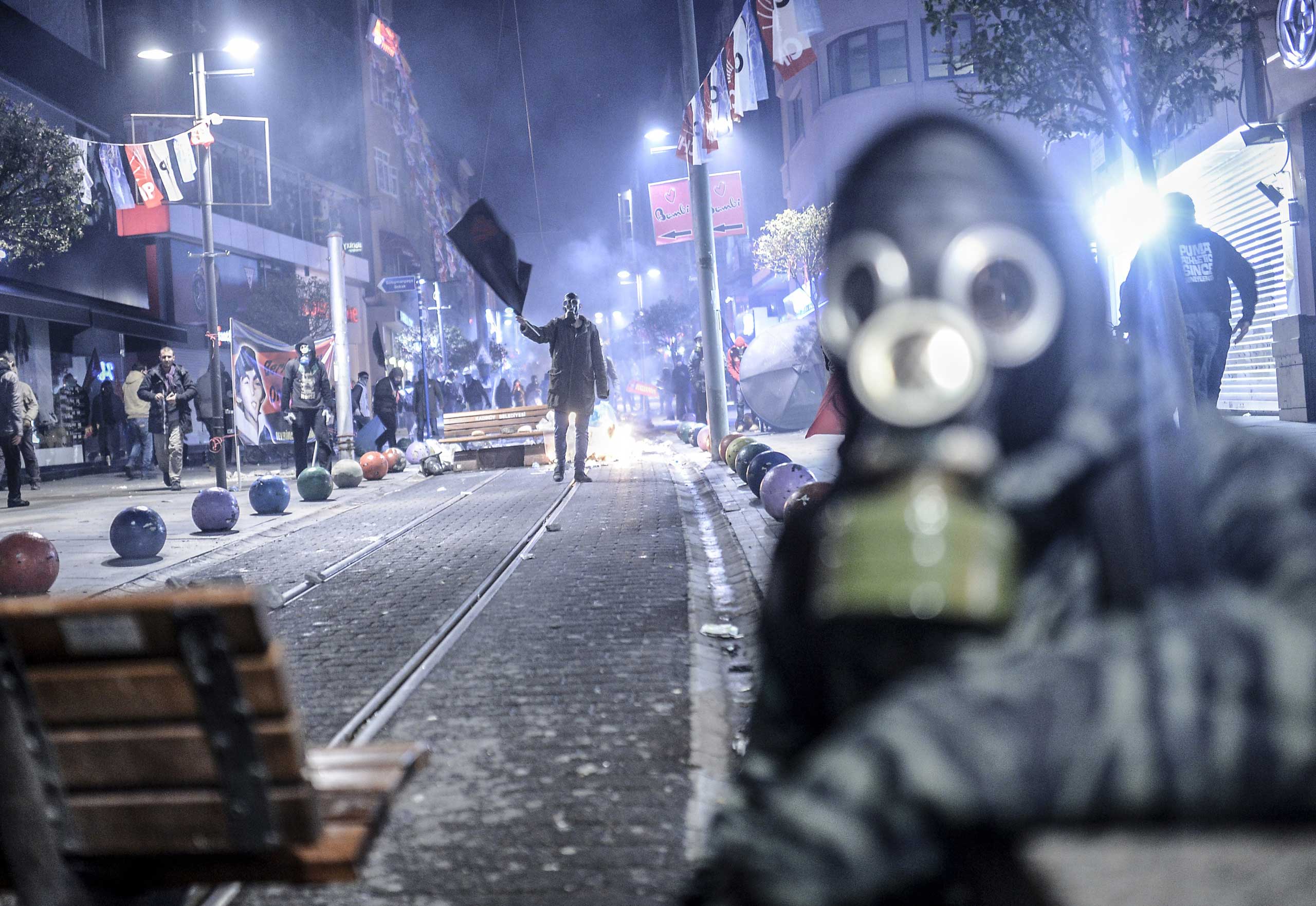 Turkey: Protests after the death of a teenage boy  who had been left comatose during a police crackdown on anti-government protests in 2013A protester waves a black flag during clashes with riot police in Kadikoy, on the Anatolian side of Istanbul, on March 11, 2014.