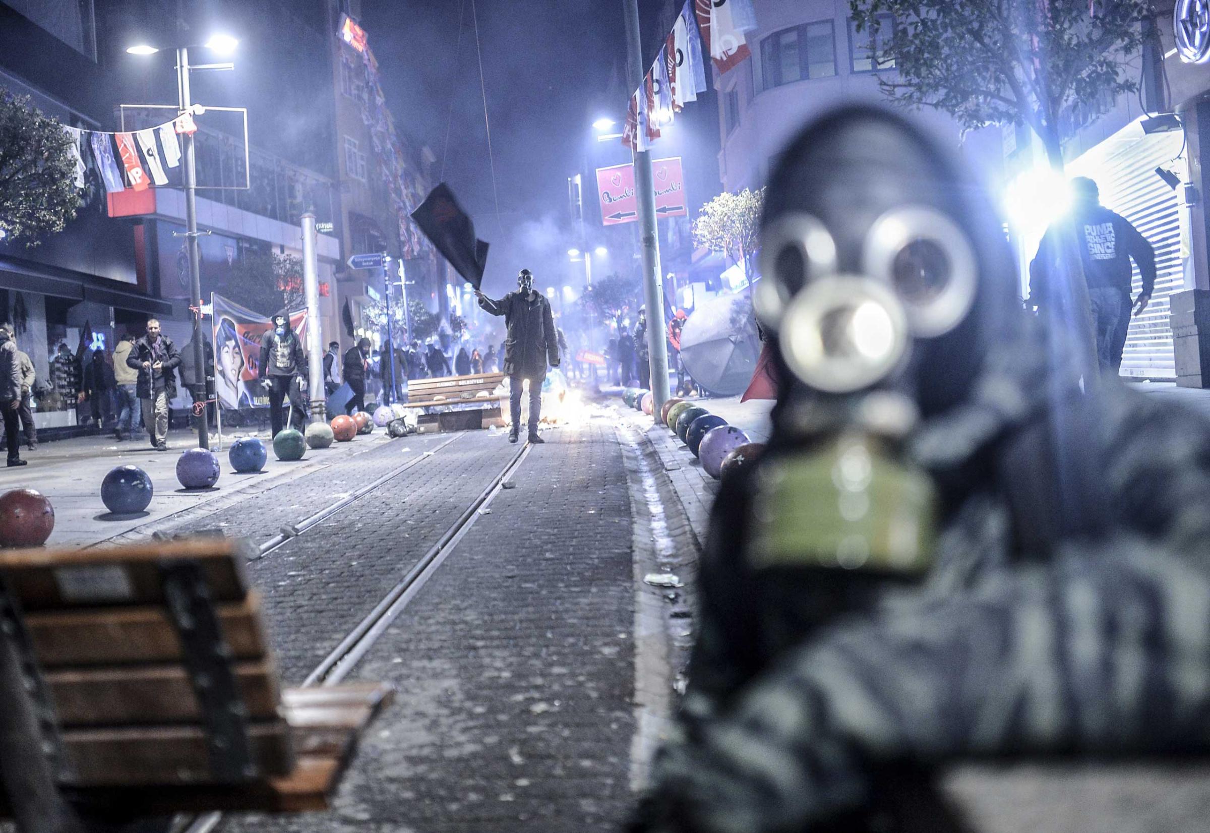 A protester waves a black flag during clashes with riot police in Kadikoy, on the Anatolian side of Istanbul, on March 11, 2014.