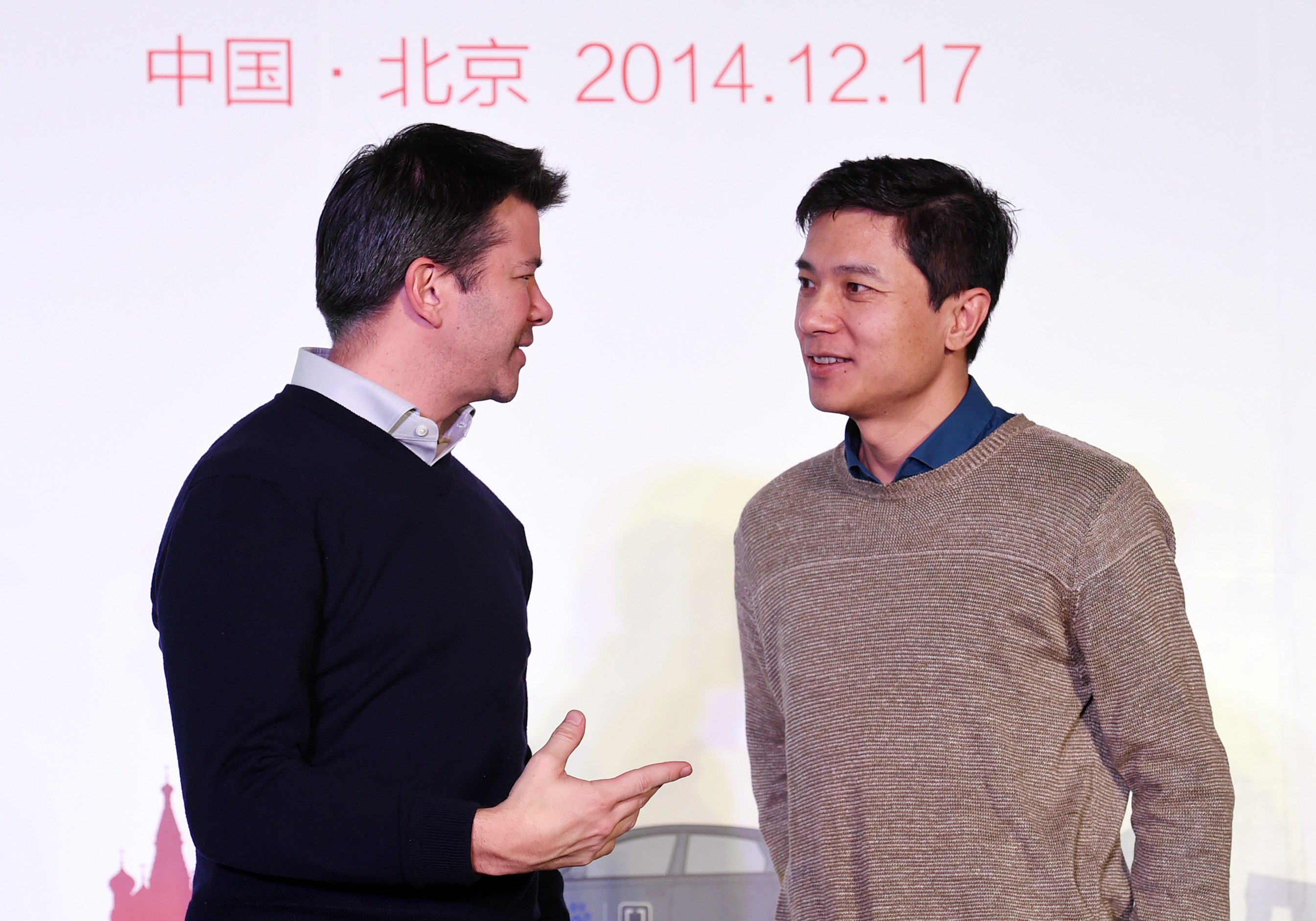 Uber CEO Travis Kalanick (L) and Baidu Chairman and CEO Robin Li at a signing ceremony and press conference in Beijing on Dec. 17, 2014. (Greg Barker—AFP/Getty Images)