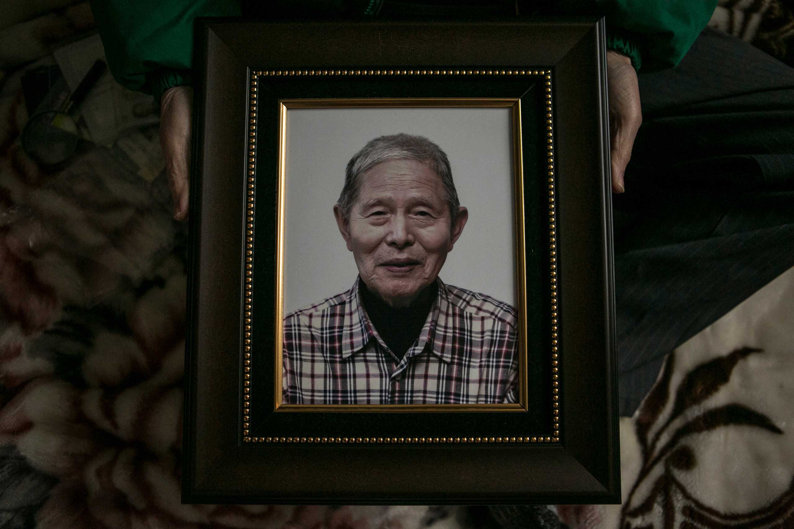 Ham Hak-joon shows a photo of him, which will be used in his funeral, in his one-room home on top of the hill in Jongro District, Seoul, Dec. 27, 2014. (Jean Chung for TIME)