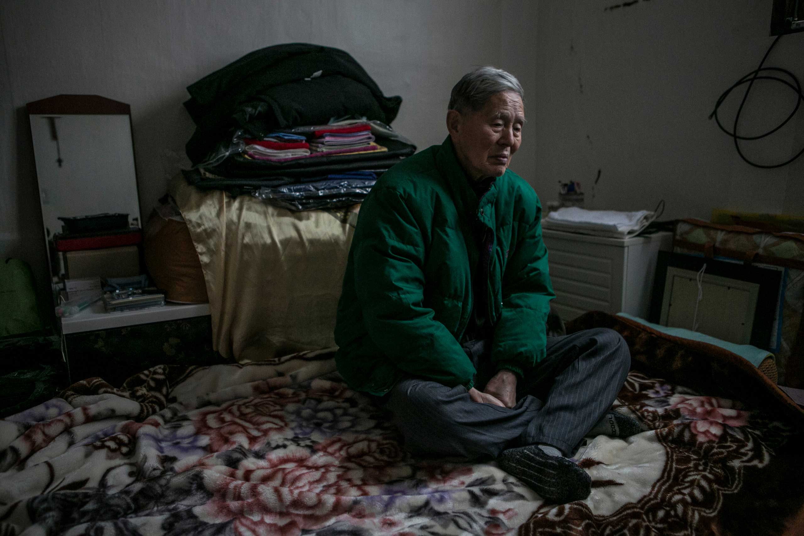 Ham Hak-joon sits in his one-room home on top of the hill in Jongro District, Seoul, South Korea in Dec. 27, 2014. Ham, an 86-year-old man who lives by himself, has been out of contact with two of his grown-up children for more than 30 years. He has arranged a funeral with Good Nanum when the time comes. (Jean Chung for TIME)