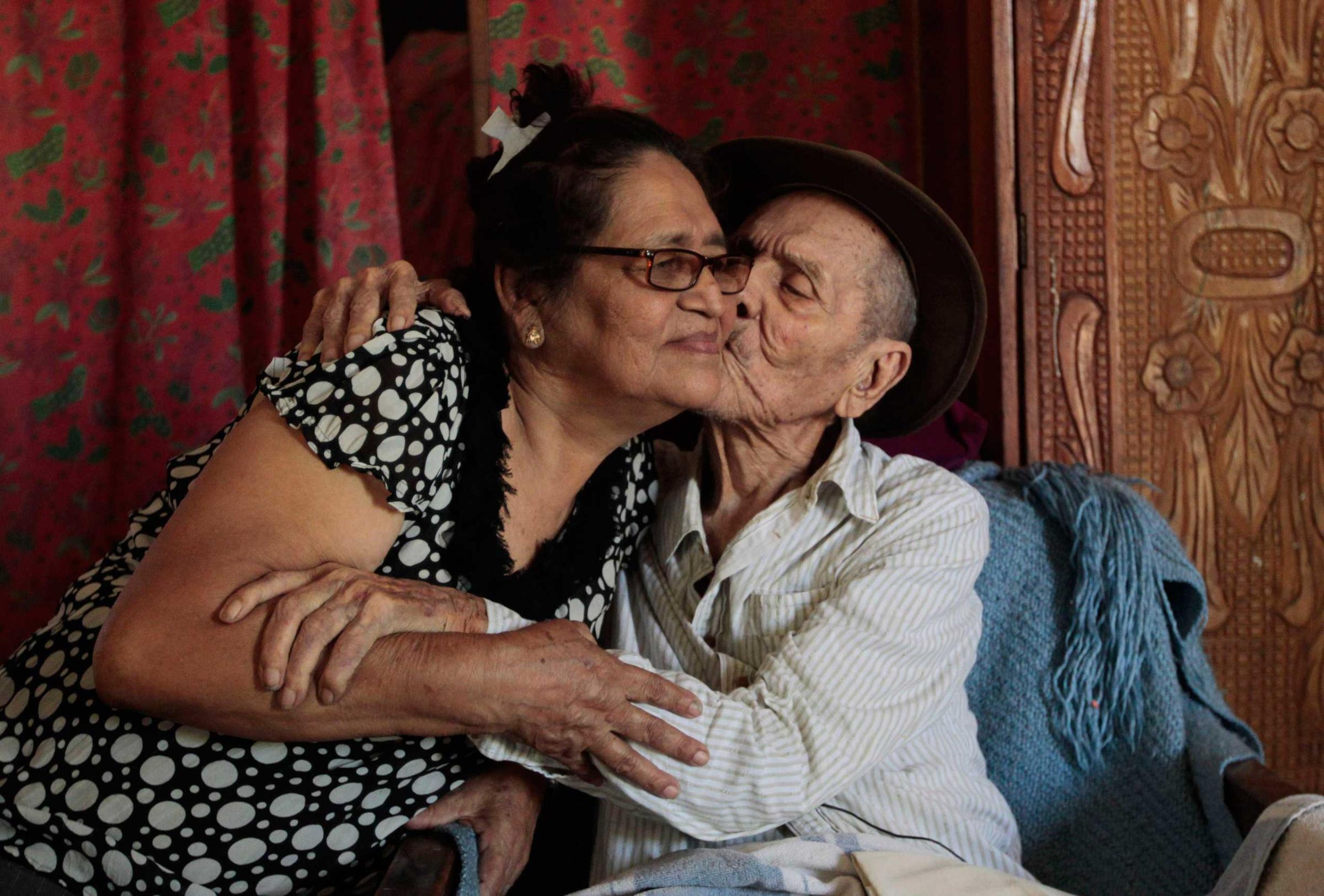 Hector Gaitan, 110, kisses his wife Nora Campo inside his home, at an abandoned station of the Nicaraguan Railway Company, the country's defunct railway in Managua.