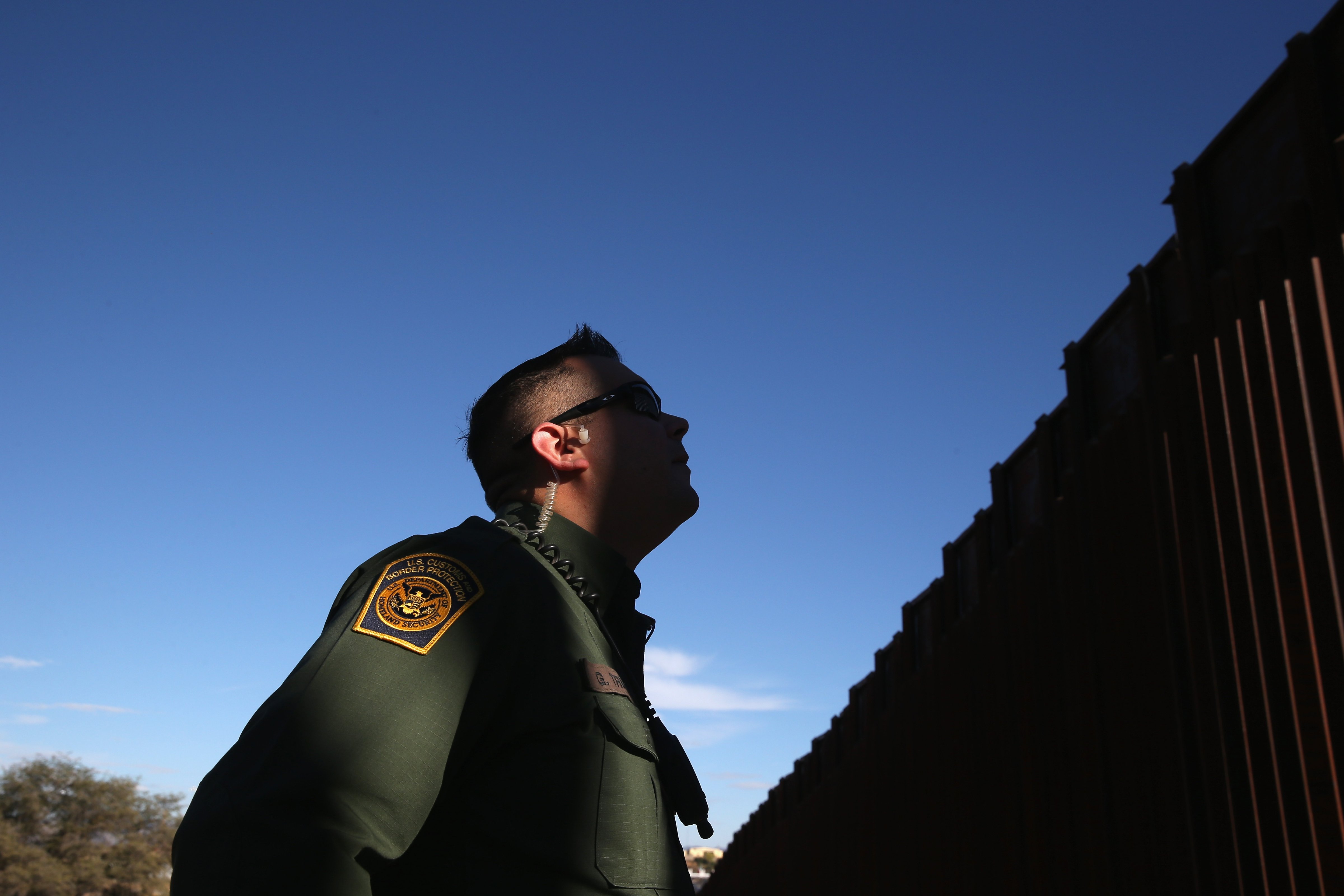 A U.S. Border Patrol agent stands next to the U.S.-Mexico border fence on Dec. 9, 2014 in Nogales, Ariz. (John Moore&mdash;Getty Images)