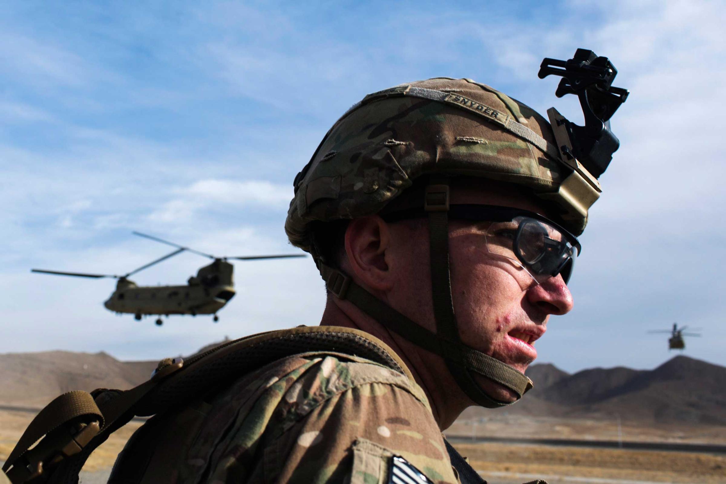A U.S. soldier waits for a CH-47 Chinook helicopter from the 82nd Combat Aviation Brigade to land after an advising mission at the Afghan National Army headquarters for the 203rd Corps in the Paktia province of Afghanistan