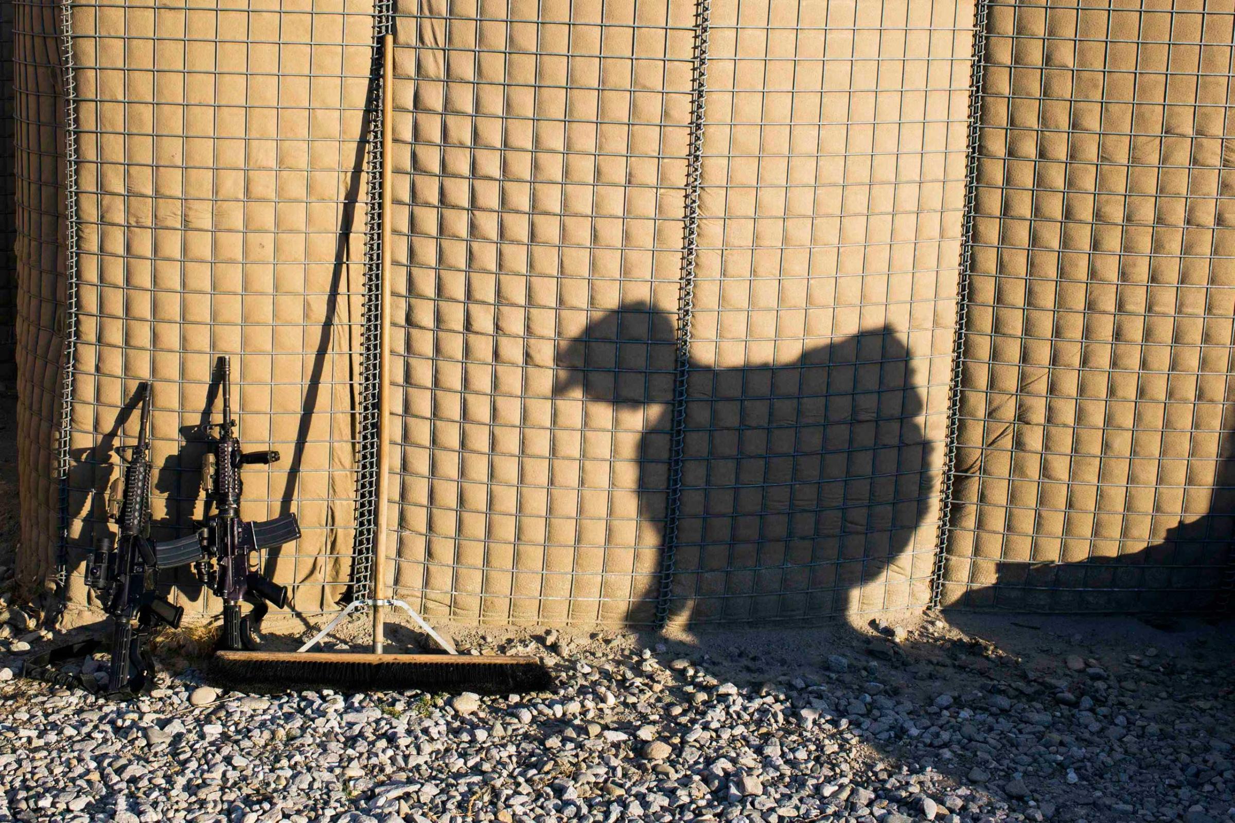 A U.S. soldier carries a backpack to a shipping container during preparations for leaving Afghanistan
