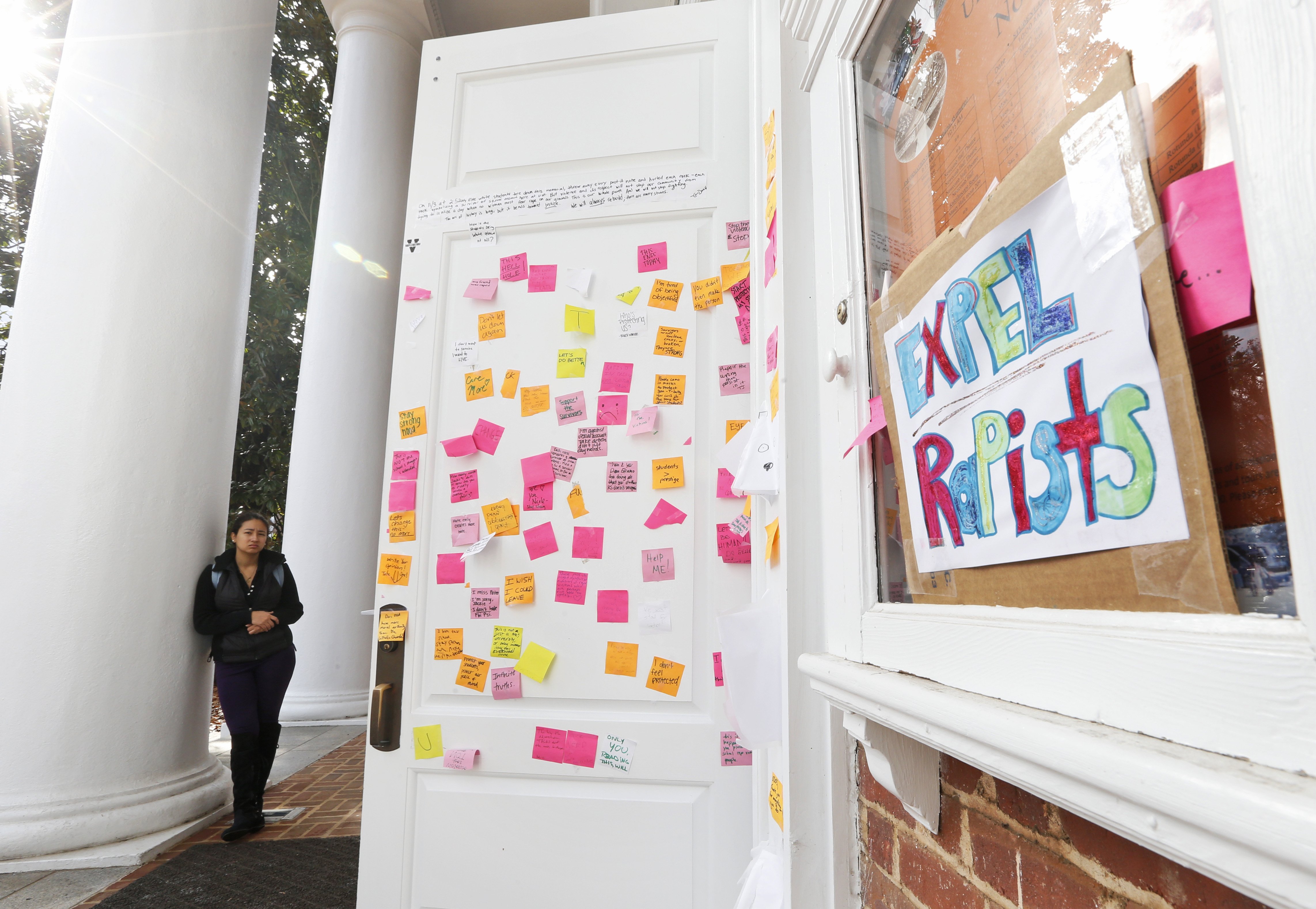 A University of Virginia student looks over postings on the door of Peabody Hall related to the Phi Kappa Psi gang rape allegations at the school in Charlottesville, Va. on Nov. 24, 2014.