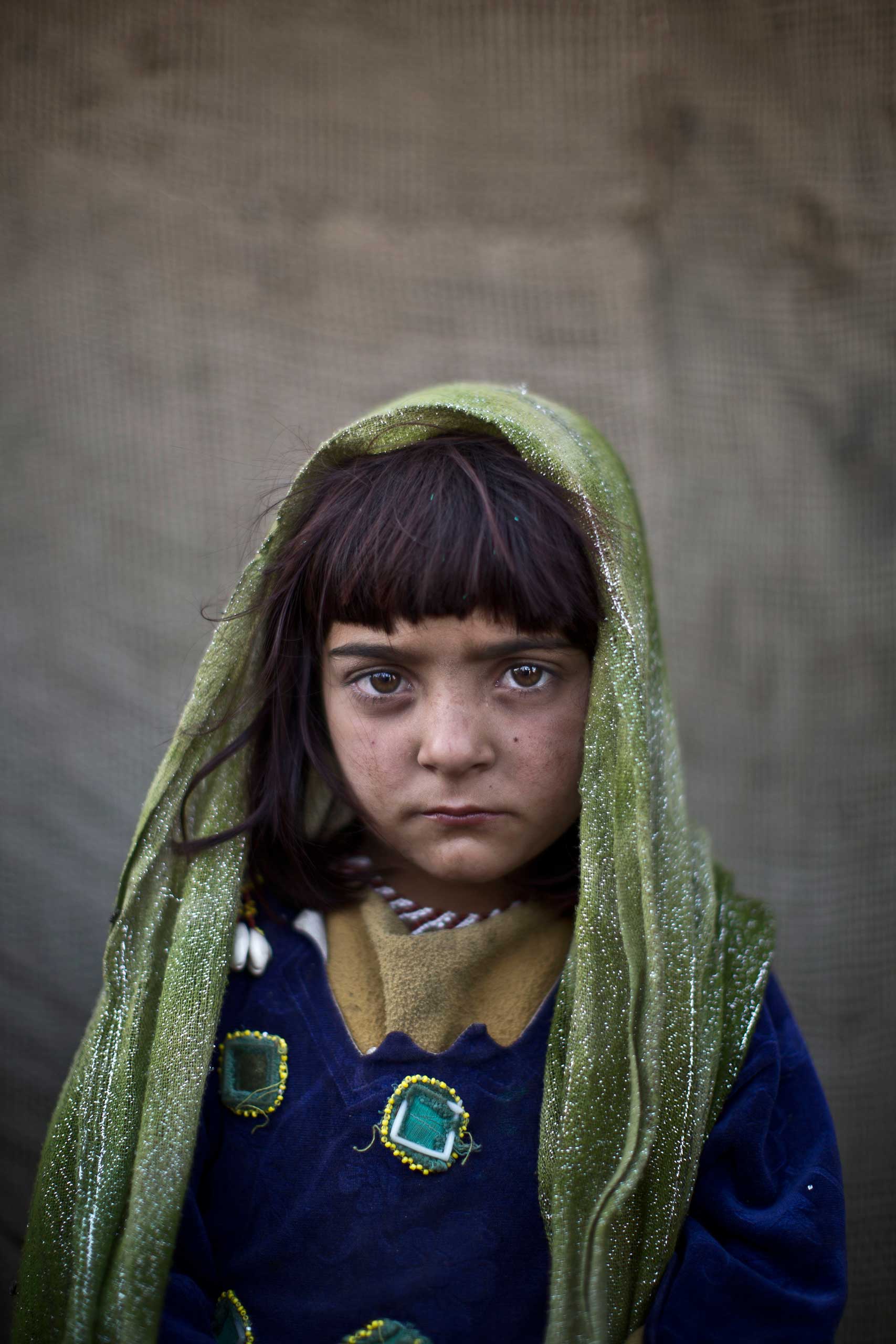 Afghan refugee girl, Zarlakhta Nawab, 6, poses for a picture, while playing with other children in a slum on the outskirts of Islamabad, Pakistan. Jan. 25, 2014.