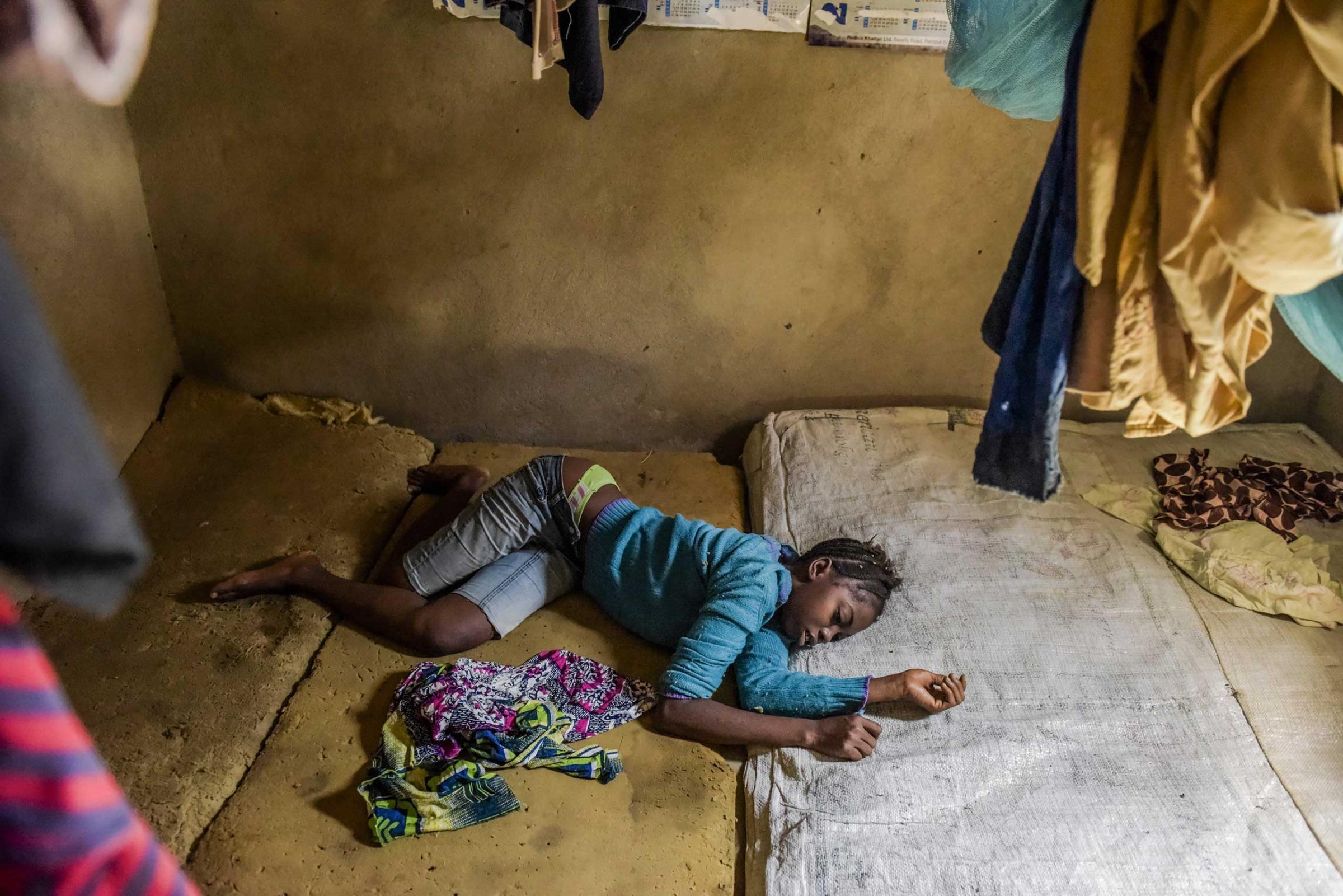 Isatu Sesay, 16, an Ebola victim, on a foam mattress writhing in pain in Kissi Town, Sierra Leone.