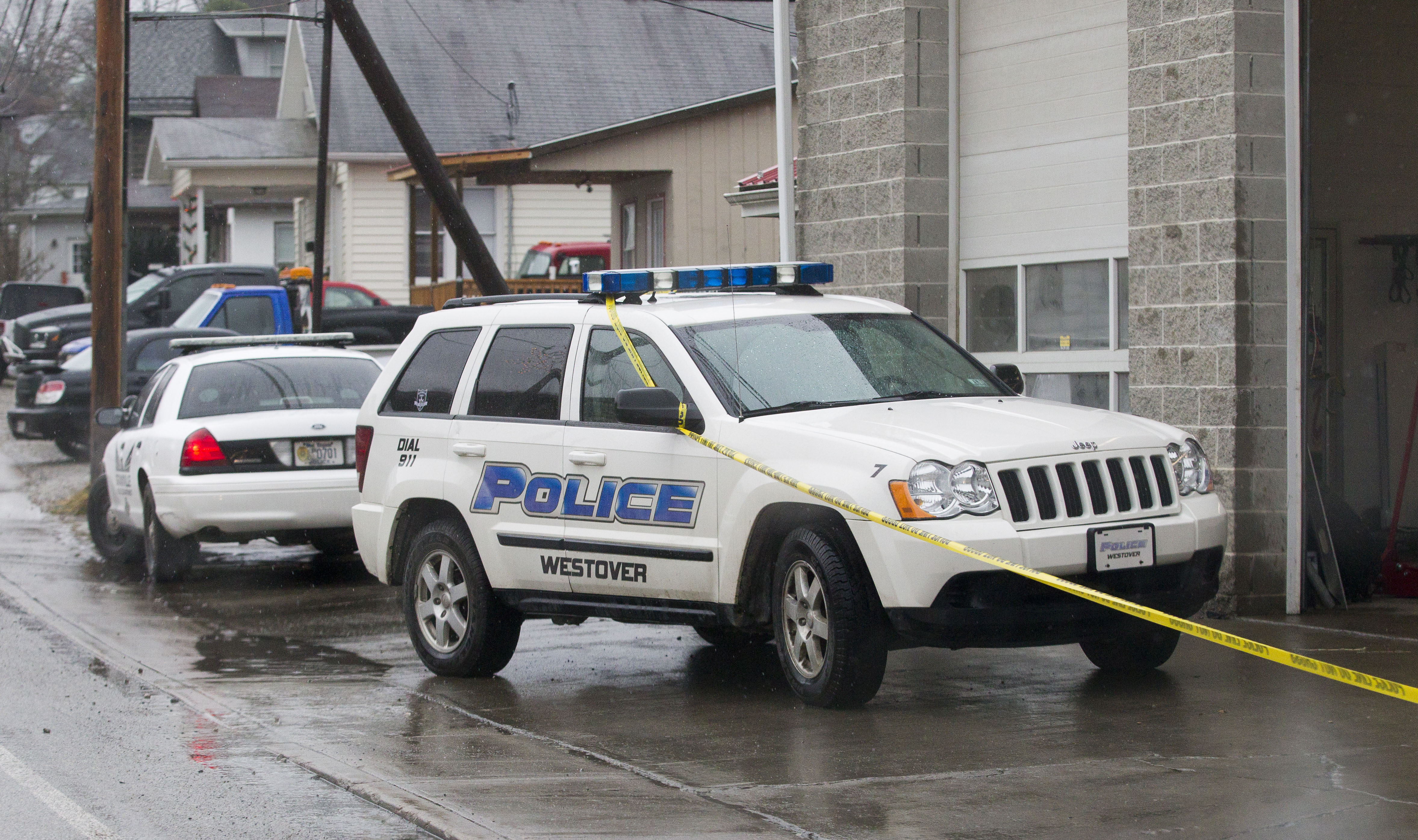 Westover Police vehicles are parked outside Doug's Towing in Westover, W.V.,, Monday, Dec. 1, 2014, after three separate shootings left four people dead on Monday. (Ben Queen–AP)