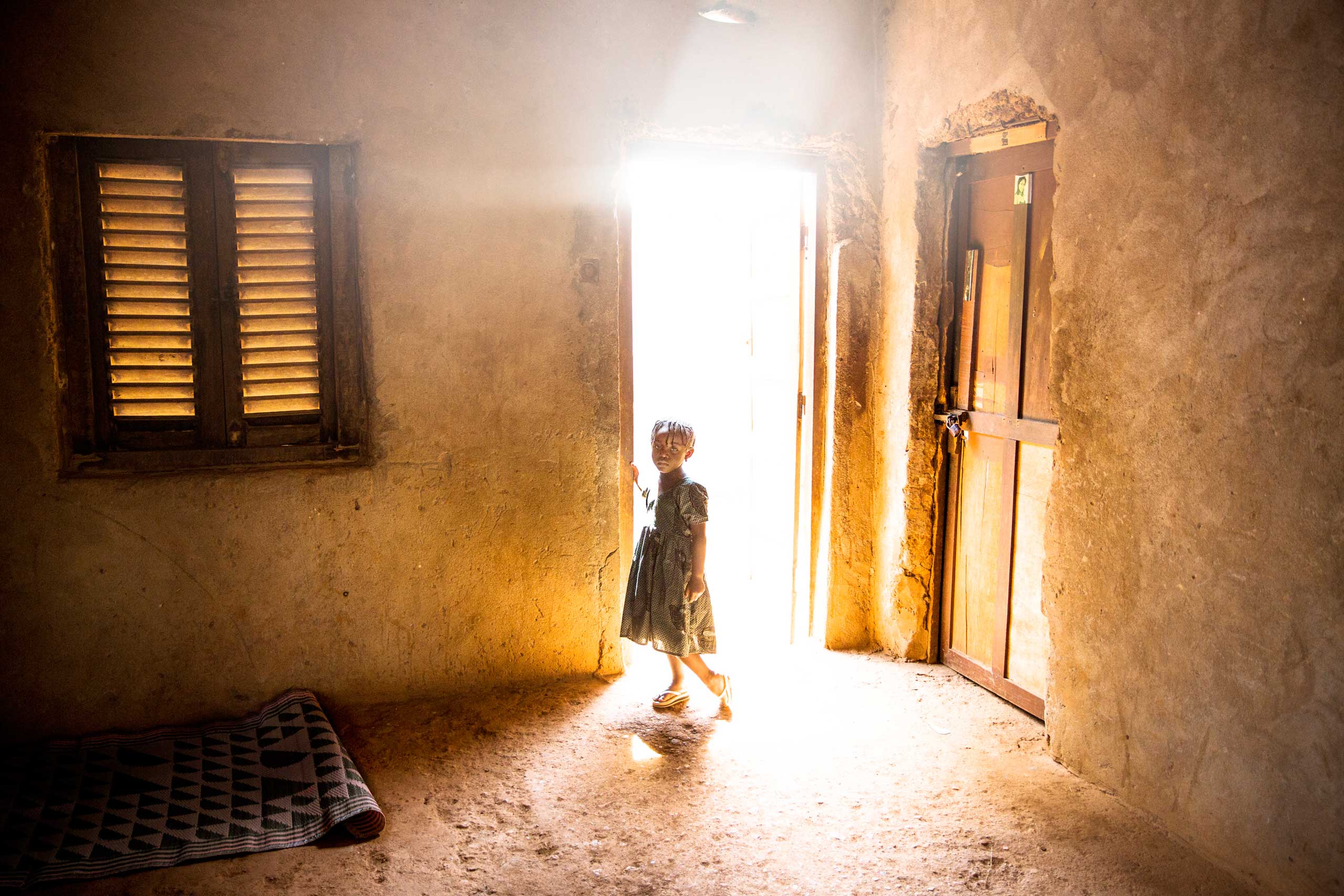 A young girls stands in the doorway of a house, two days after a member of her family was killed by a grenade said to be launched by a member of Séléka. Bangui, Central African Republic. Nov. 14, 2013.