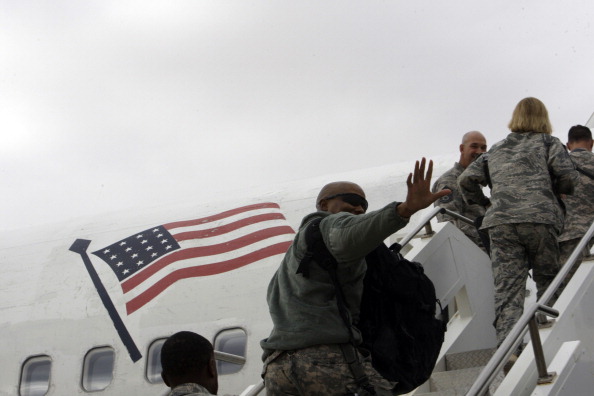 US army soldiers board a plane to begin