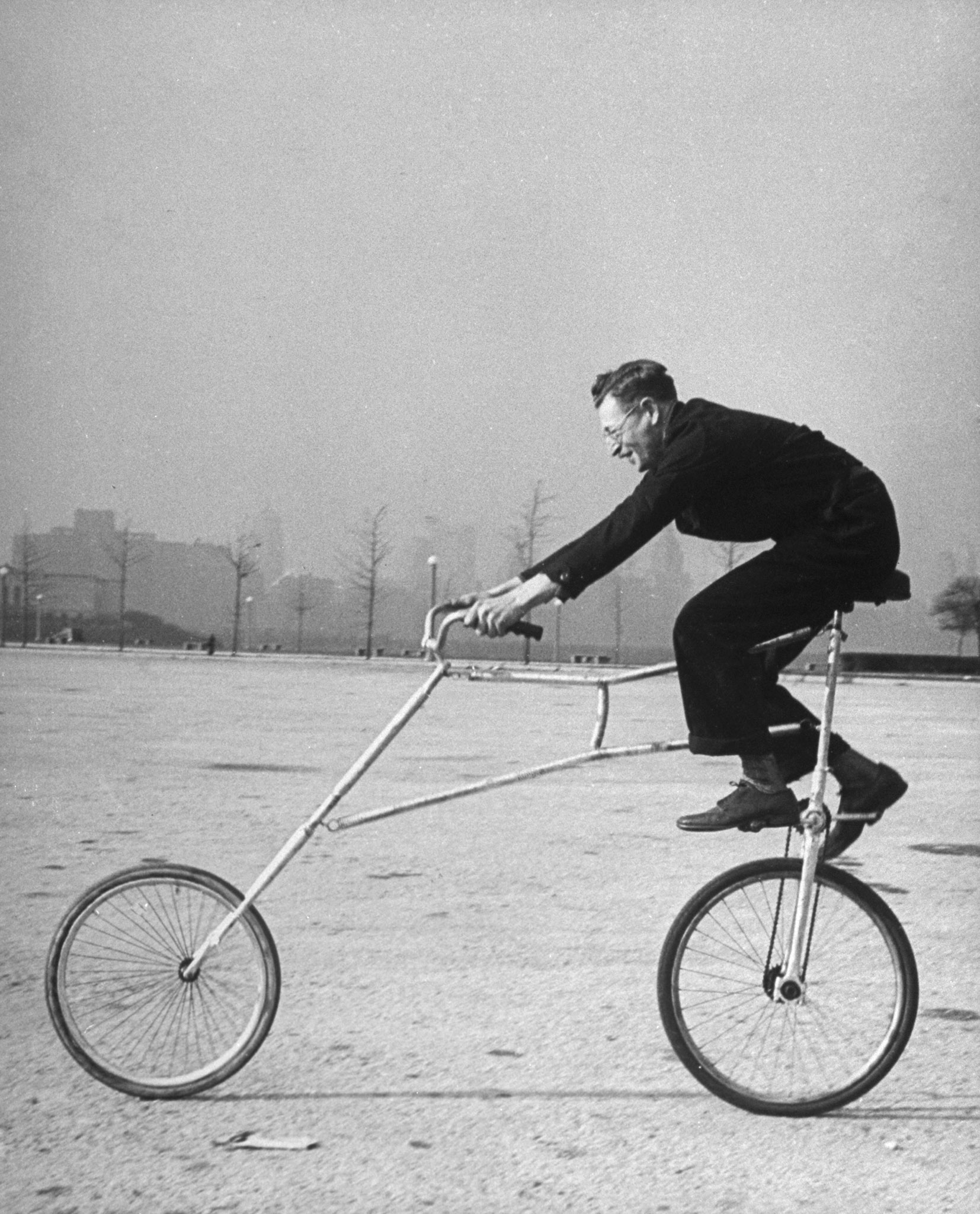 Inventor Maurice Steinlauf riding eccentric bike with roving front wheel.