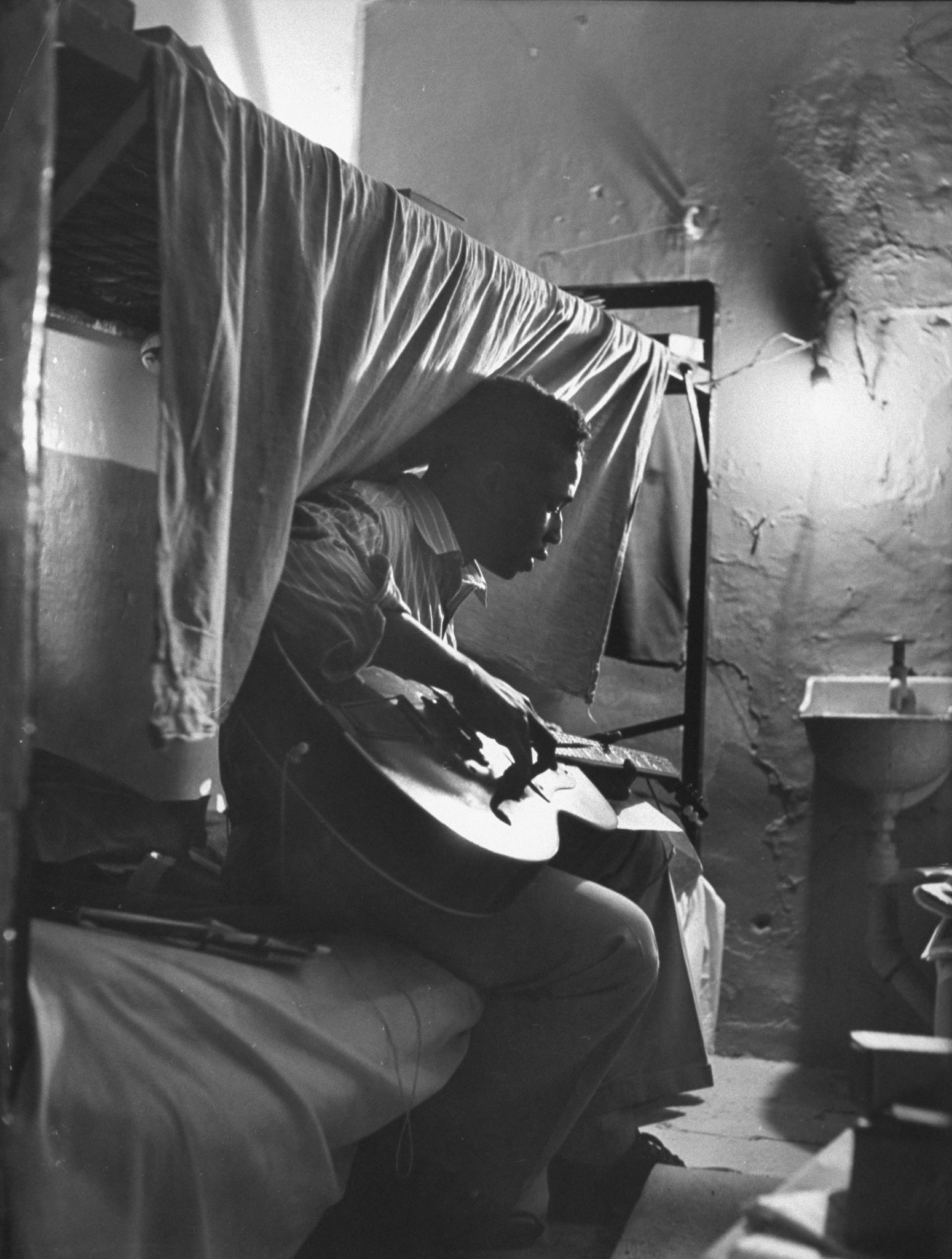 Robert Riley, serving 10 to 16 years for housebreaking, sits in his cell composing music, Tennessee State Penitentiary, 1953. Riley co-wrote the hit song, "Just Walkin' in the Rain."