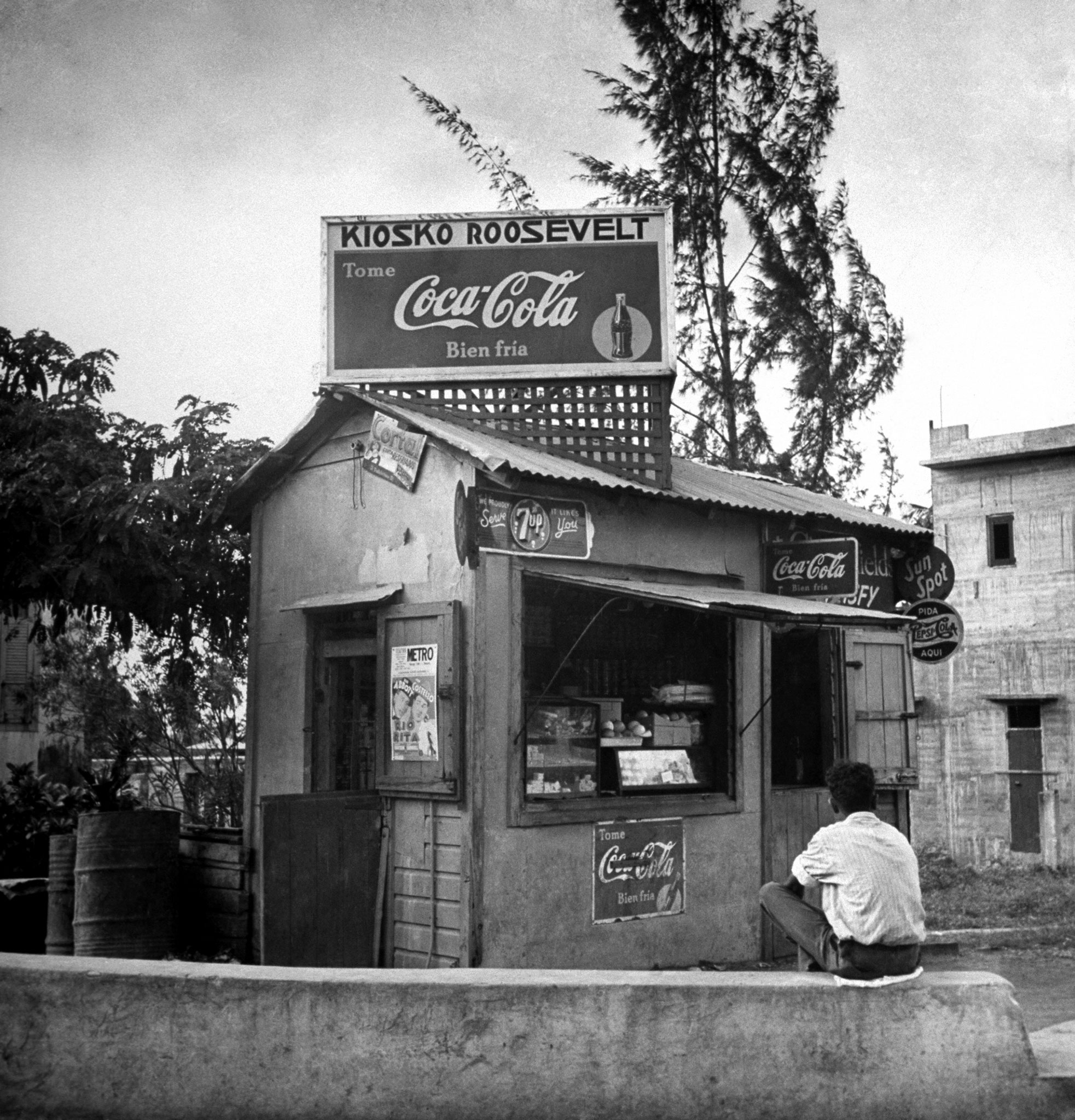 A drugstore boasts both Cokes for sale and the name of the then-first lady in Puerto Rico in 1943.