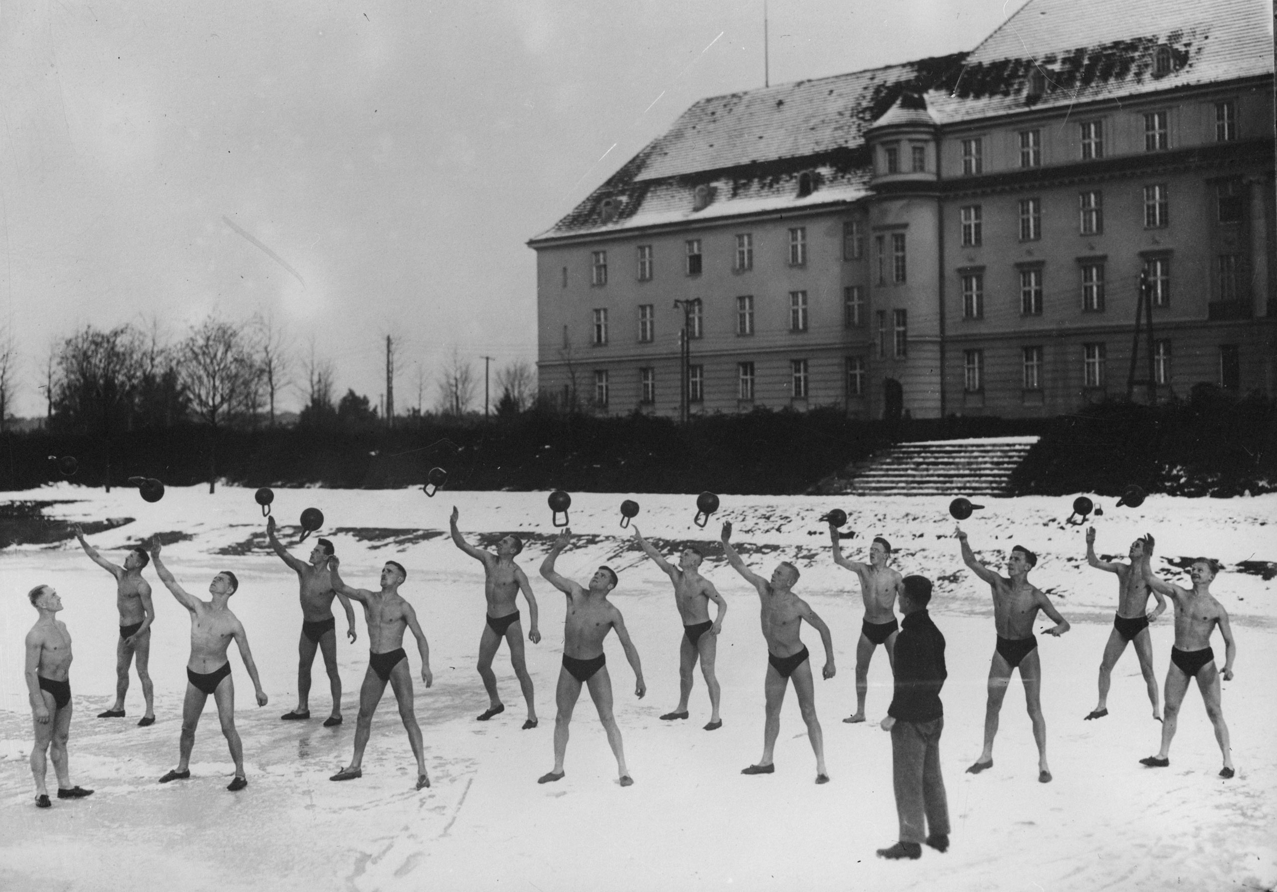 A group of determined men exercising outside in the snow, circa 1926.