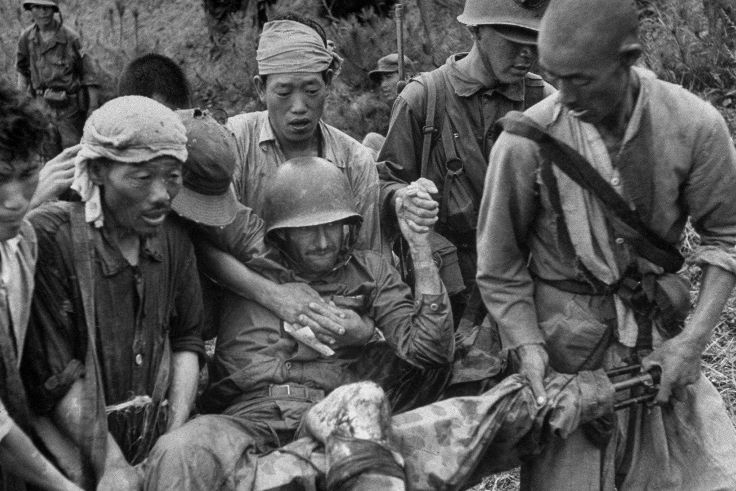 A wounded American Marine is carried on stretcher improvised from a machine gun, Korea 1950.